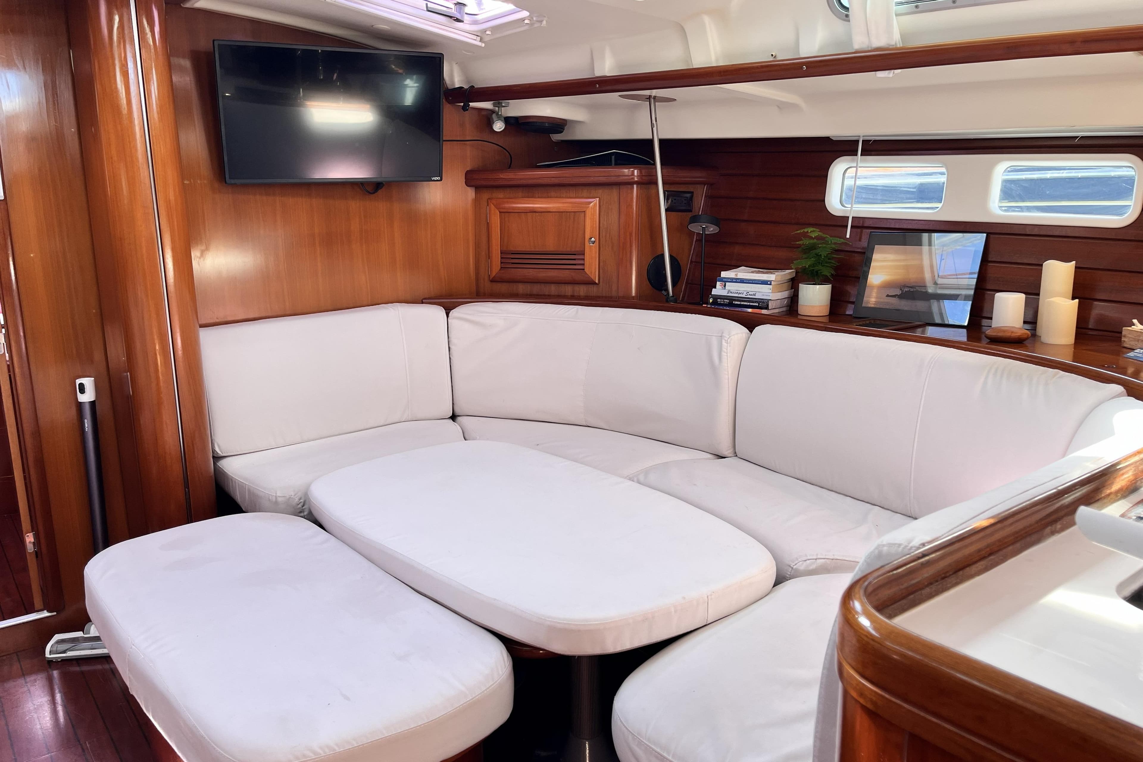 Luxurious interior of 2001 Beneteau 473 yacht with white seating and wooden accents.