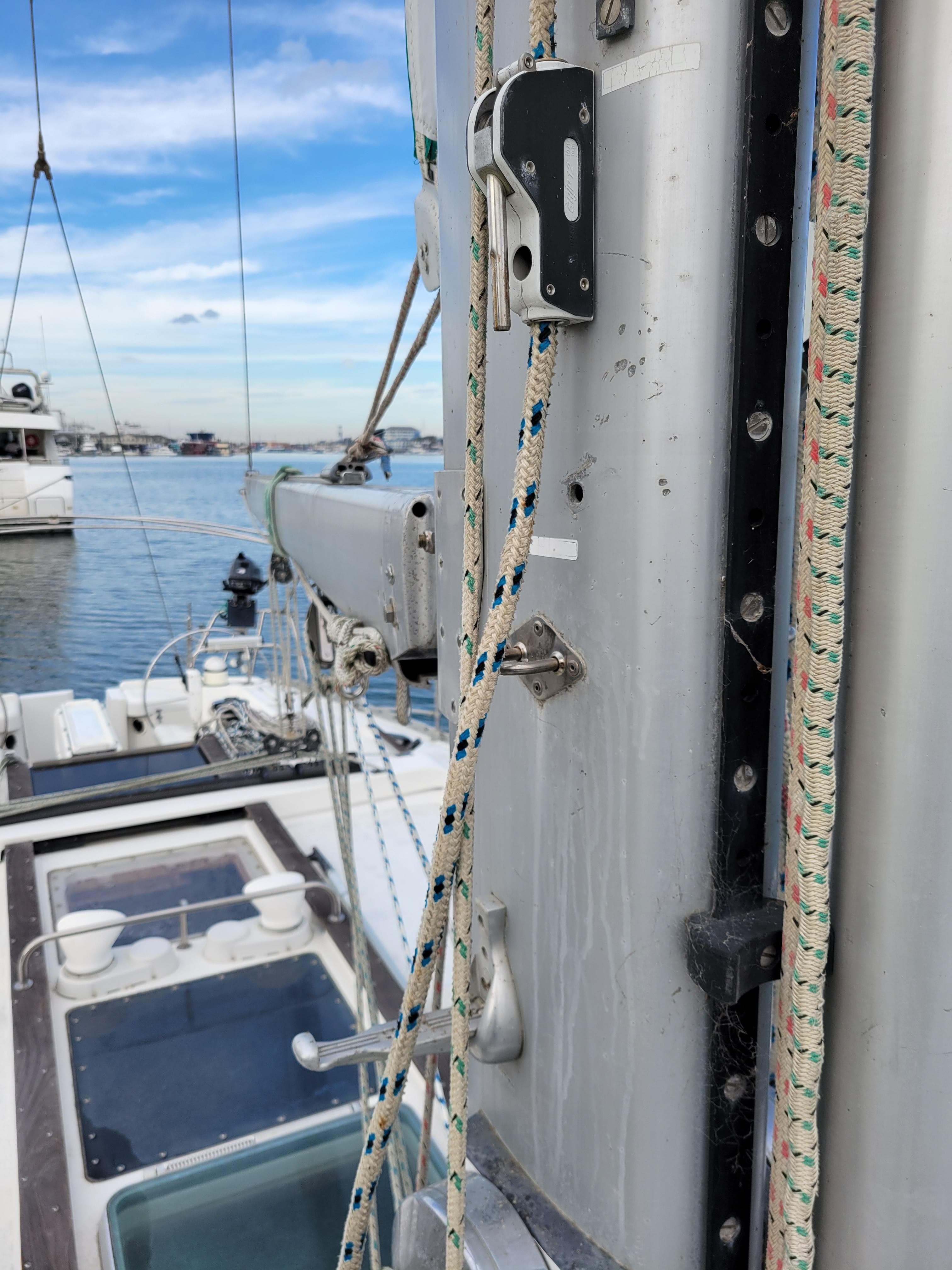 Close-up of Jeanneau Sun Odyssey 51 sailboat mast and rigging, docked in a marina.