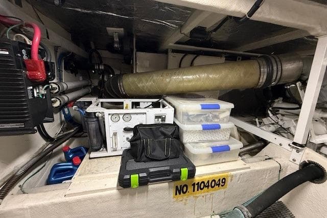 Engine room of 2001 Bayliner 5288 Pilot House Motoryacht with equipment and storage boxes.