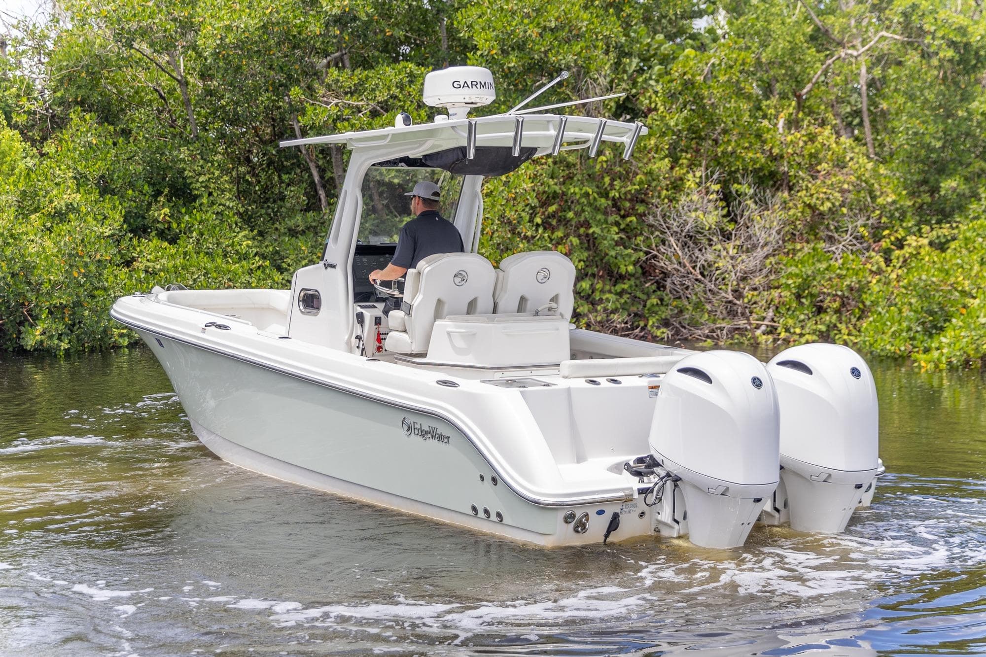2023 Edgewater 262CC boat with dual engines navigating through calm waters.