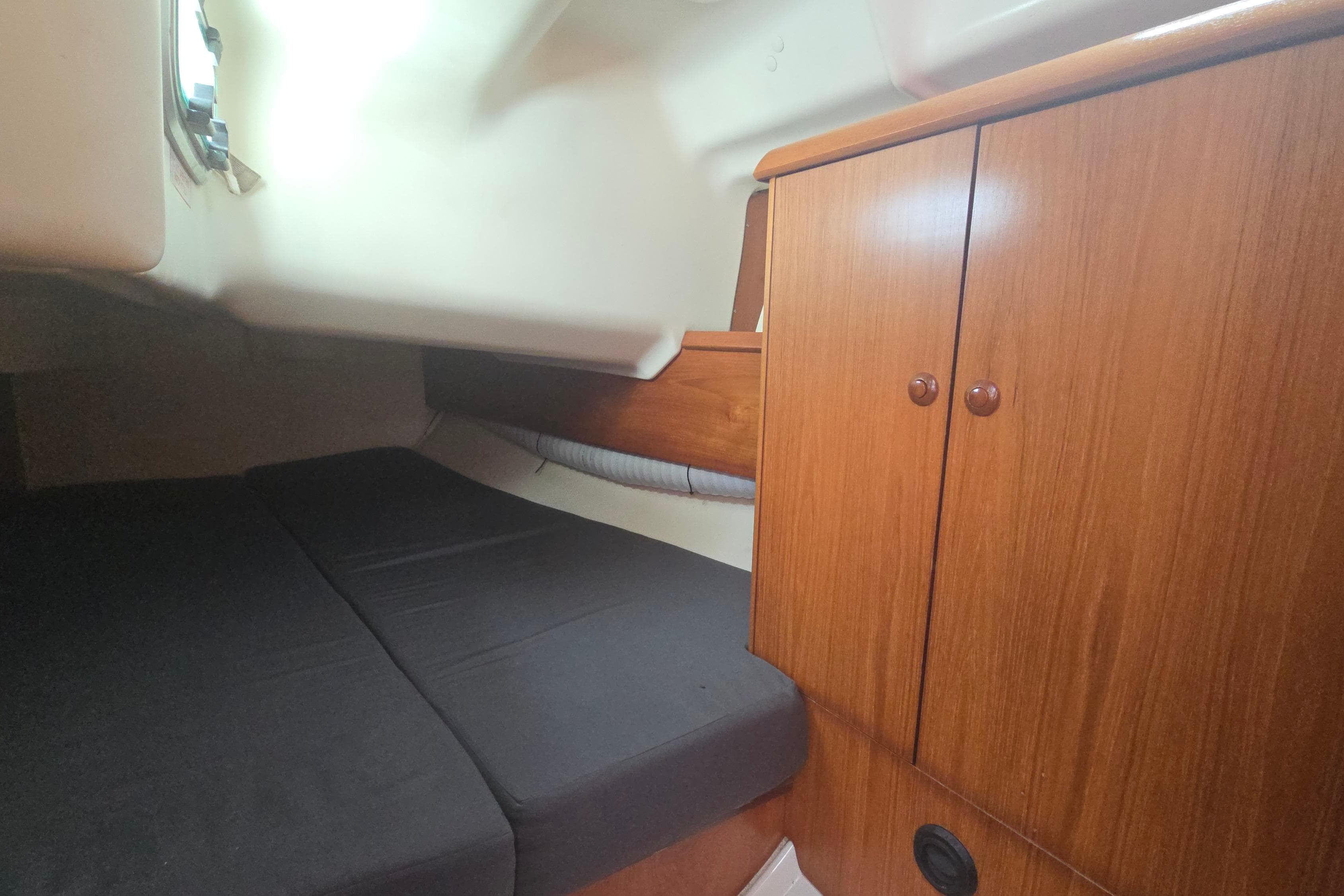 Cozy cabin interior of 2002 Jeanneau Sun Fast 37 sailboat with wooden cabinetry.