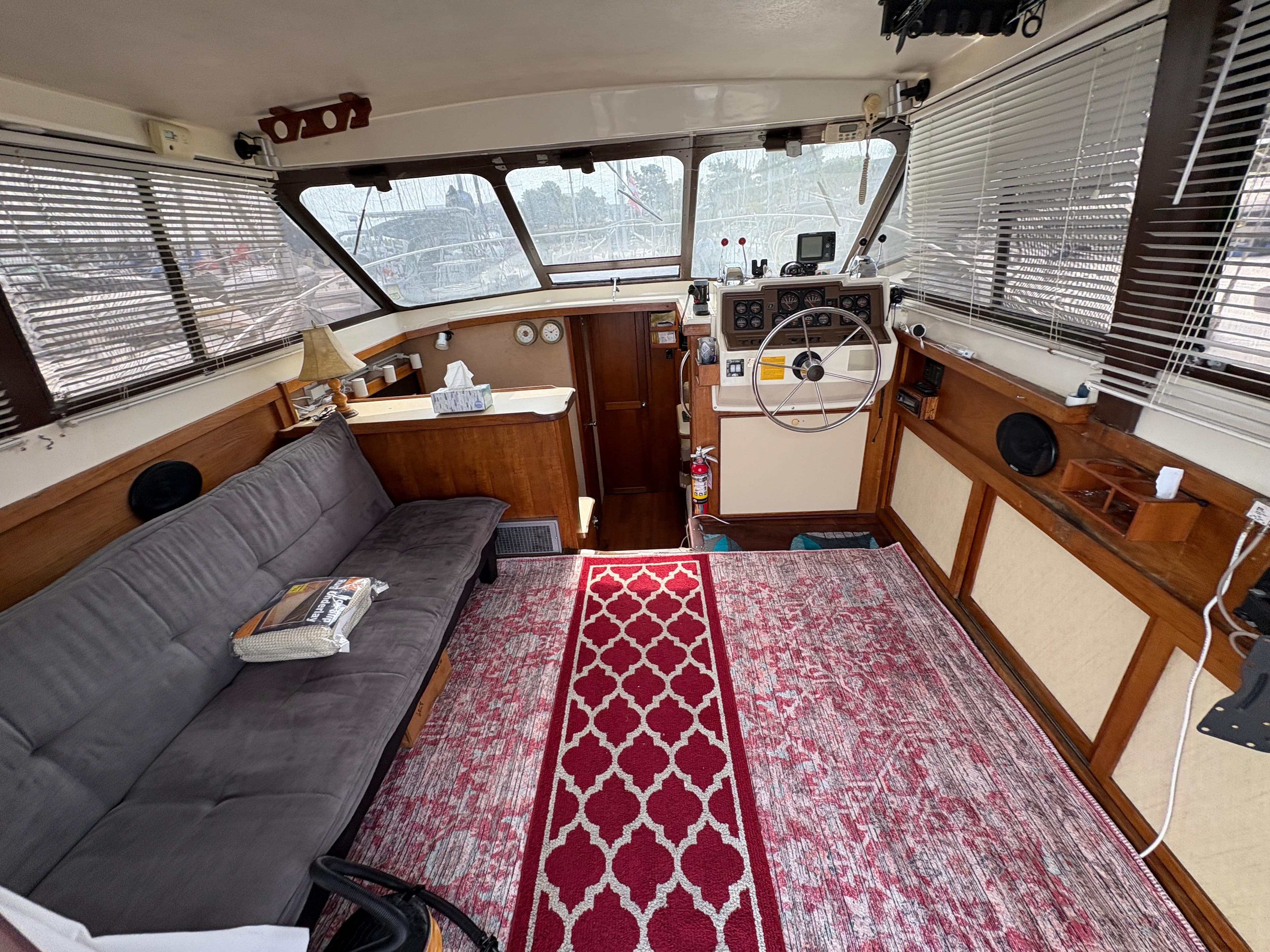 1986 Trojan 32 Sedan interior with sofa, steering wheel, and red patterned rug.