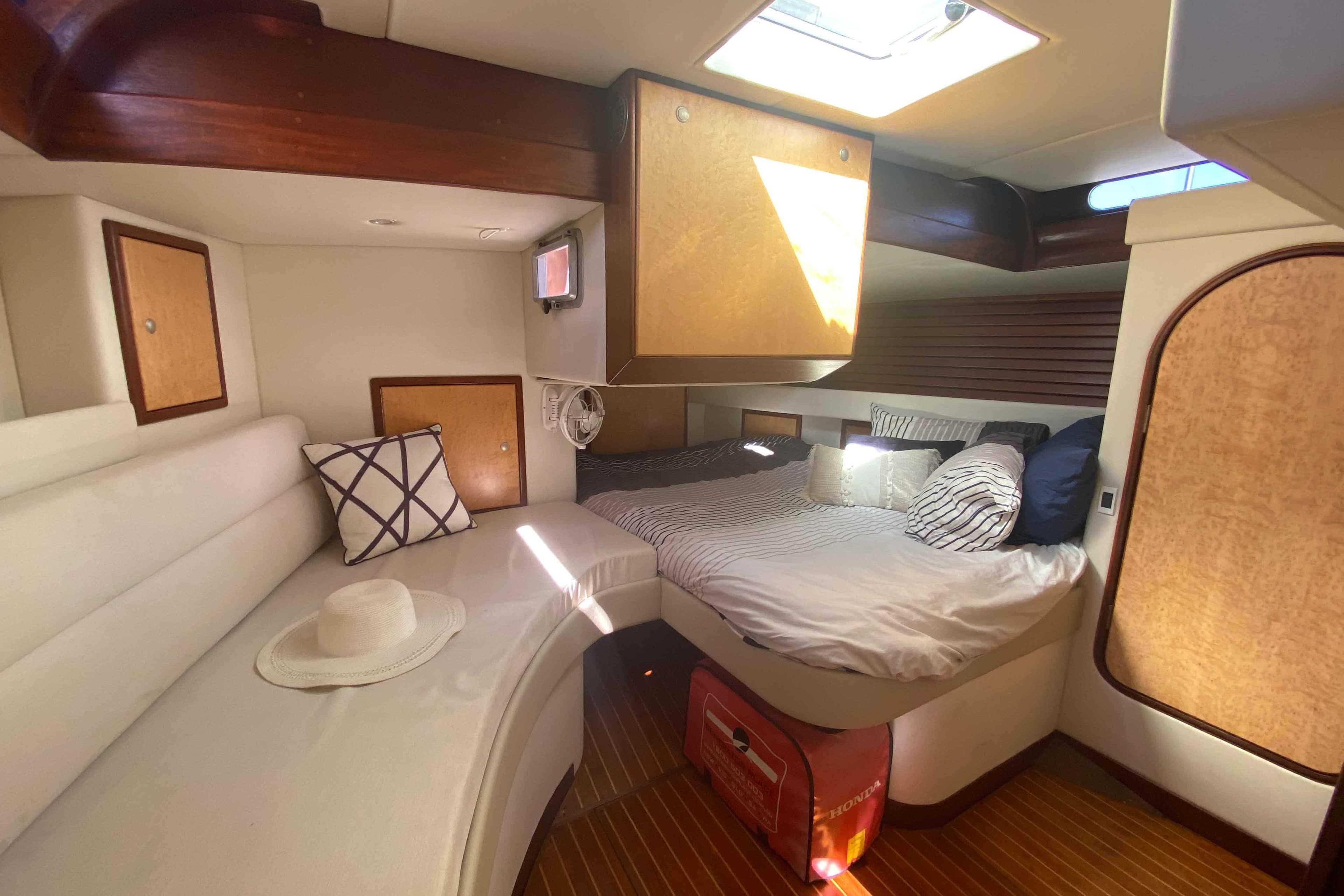 Cozy cabin interior of 1983 Sparkman & Stephens 52 yacht with bed, seating, and natural light.