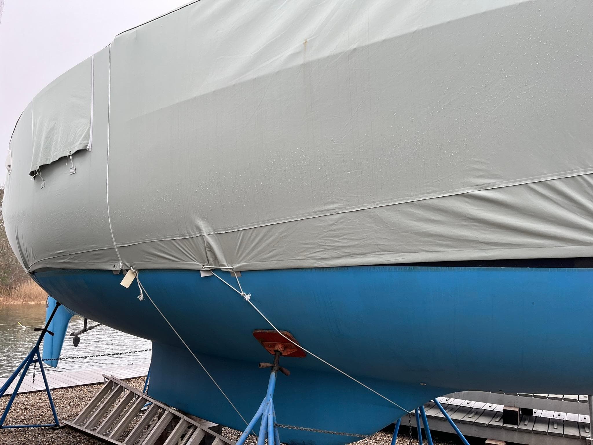 1978 Tartan 37 sailboat with blue hull and protective cover on land.