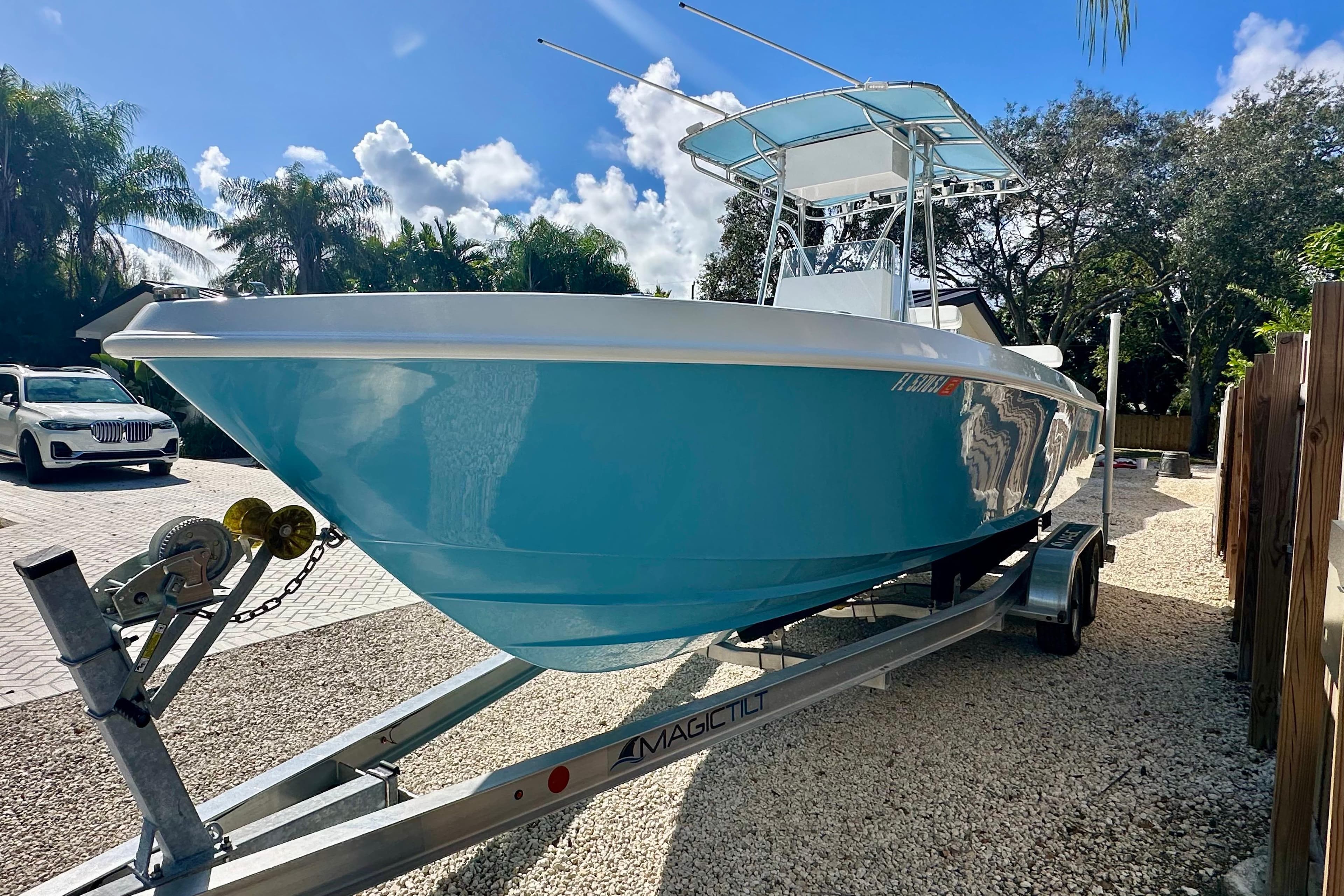 2001 Contender 23 Open boat on trailer, parked outdoors under a sunny sky.