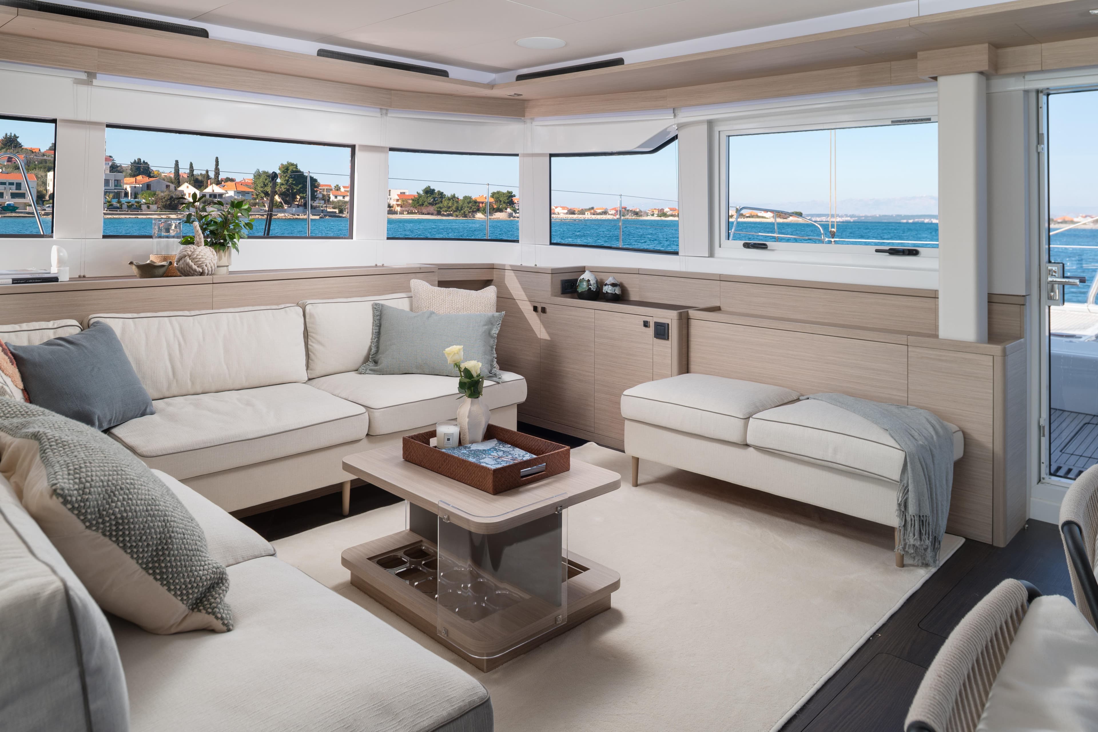 Luxurious interior of 2025 Lagoon 60 yacht with elegant seating and ocean view.