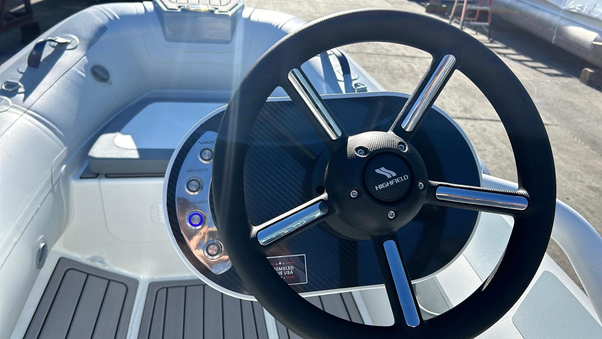 Steering wheel of 2025 Highfield CL340 boat, featuring control panel and seating area.