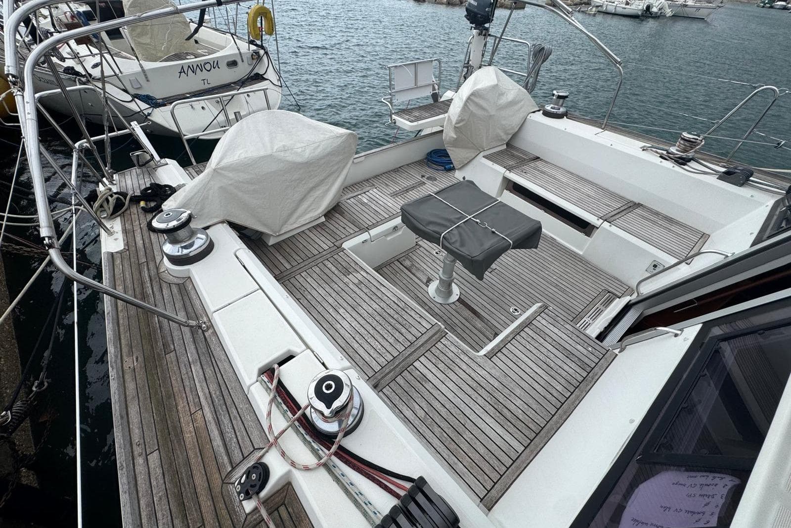 2015 Beneteau Sense 50 yacht deck with covered seating, docked at marina.