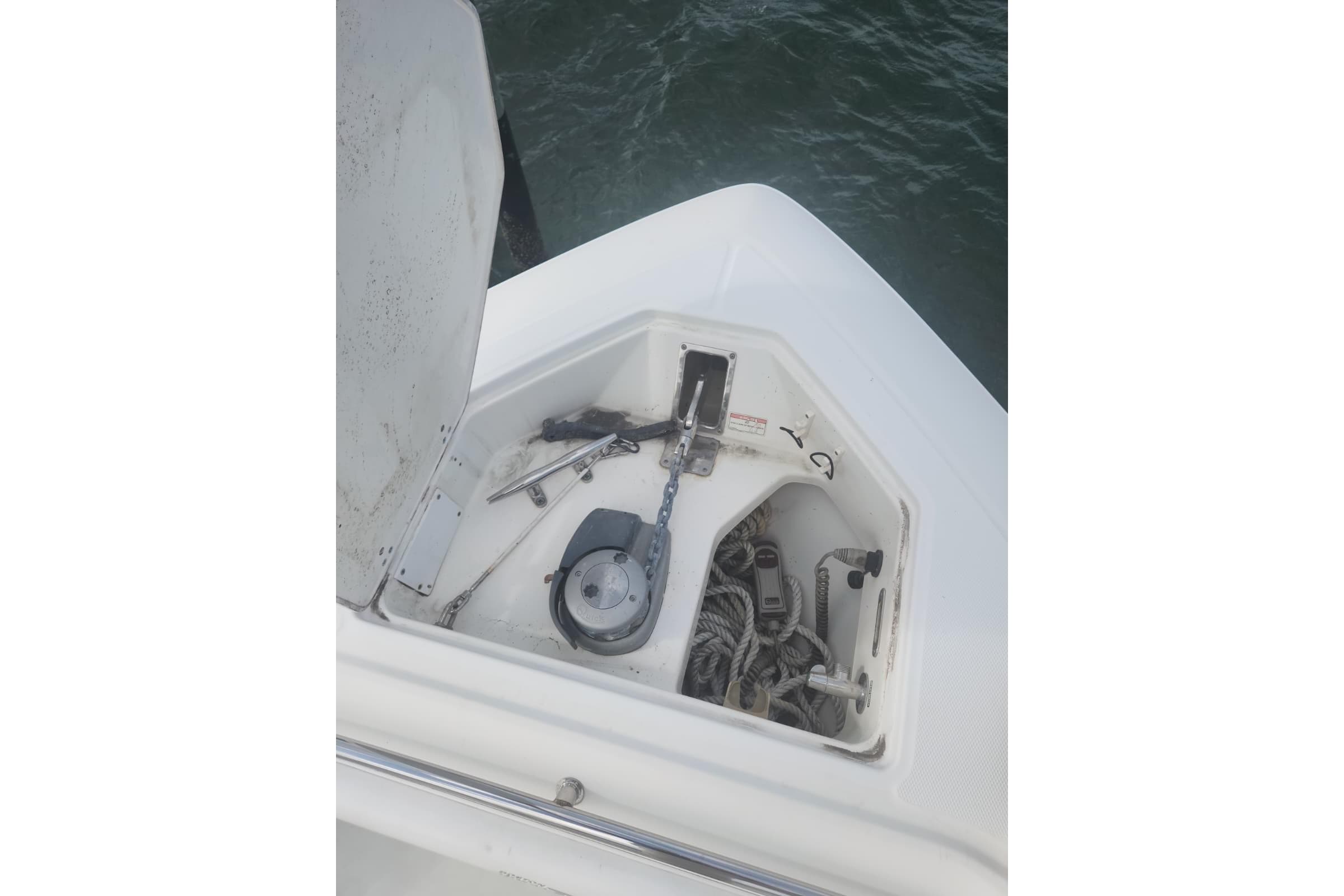 Open anchor compartment on 2014 Boston Whaler 350 Outrage boat, showing ropes and equipment.
