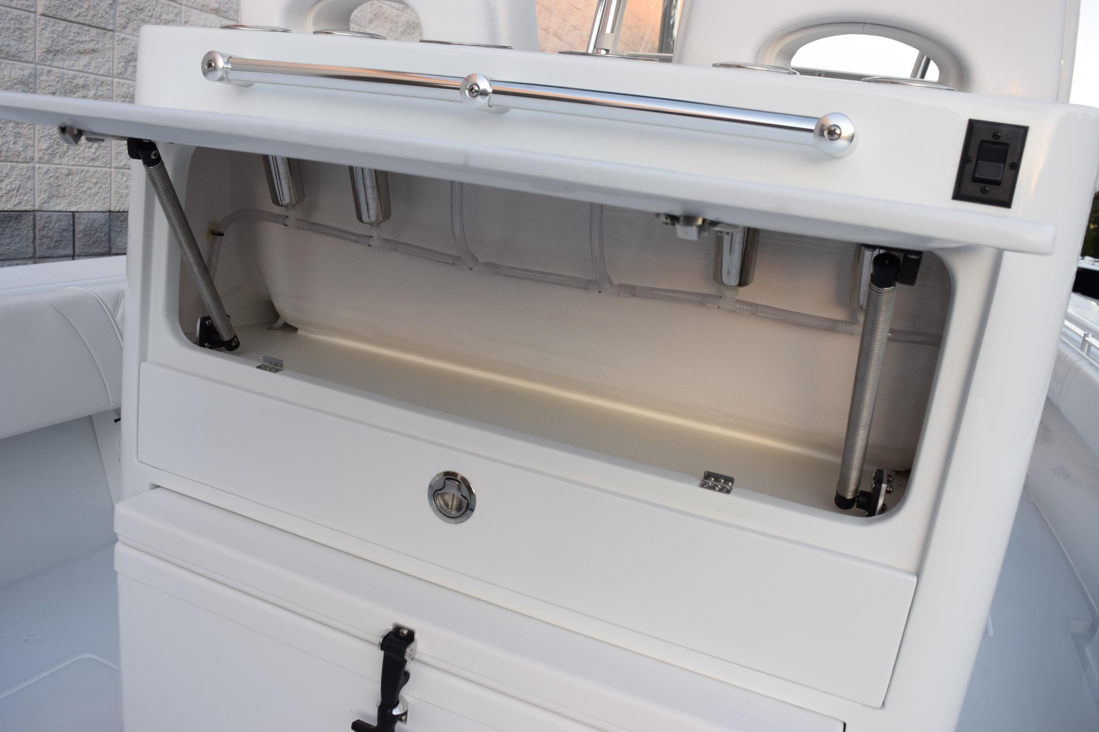 Open storage compartment on 2026 Contender 32 ST boat, showcasing interior features.