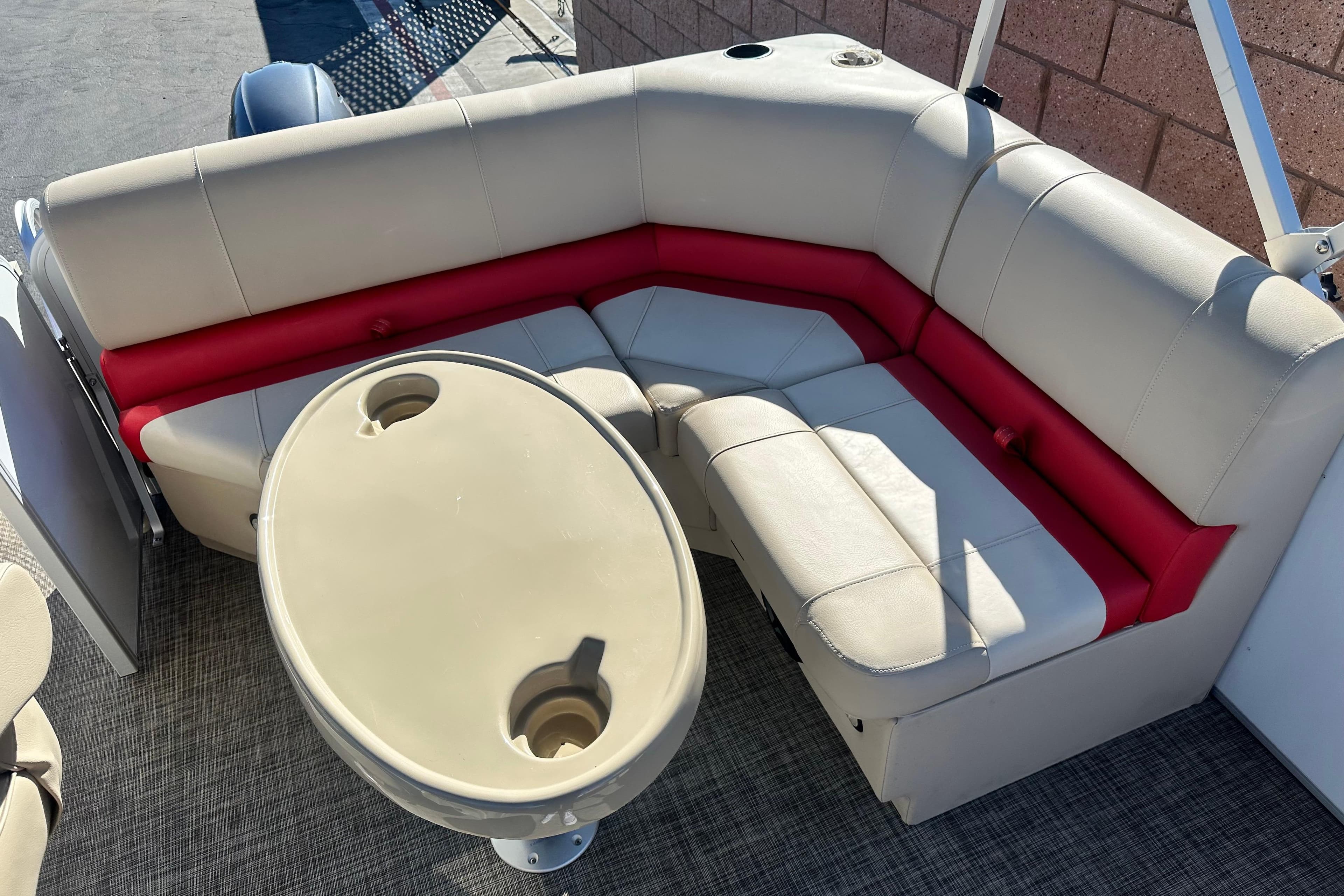 2020 G3 SunCatcher V16 Cruise pontoon boat interior with beige and red seating, oval table.