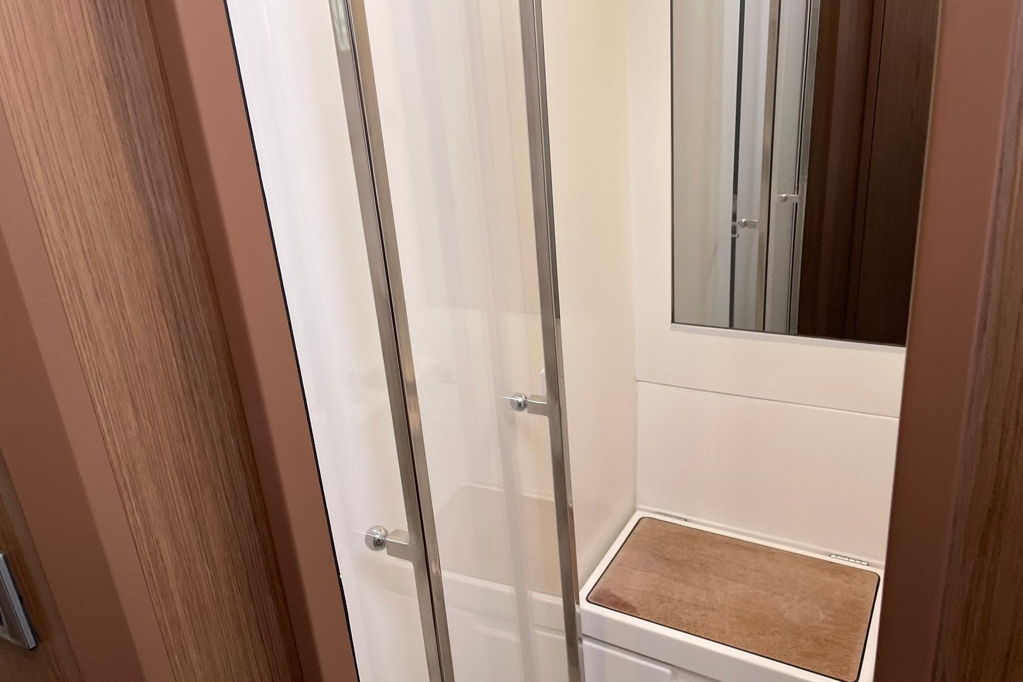 Shower area in 2017 Beneteau Sense 57 yacht, featuring sleek glass doors and wooden accents.