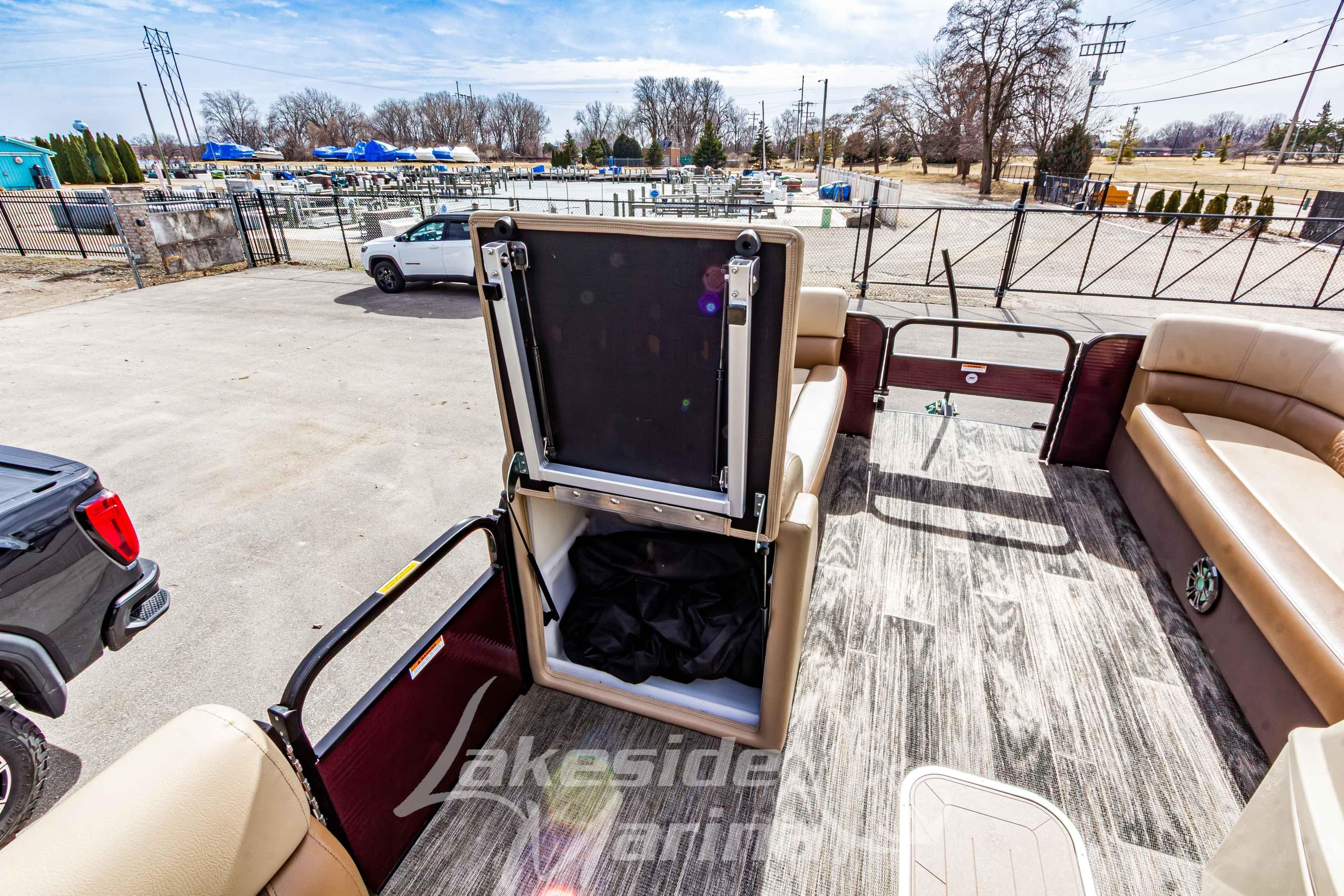 2023 Godfrey Sweetwater 2286 FS pontoon boat with open storage compartment, docked outdoors.