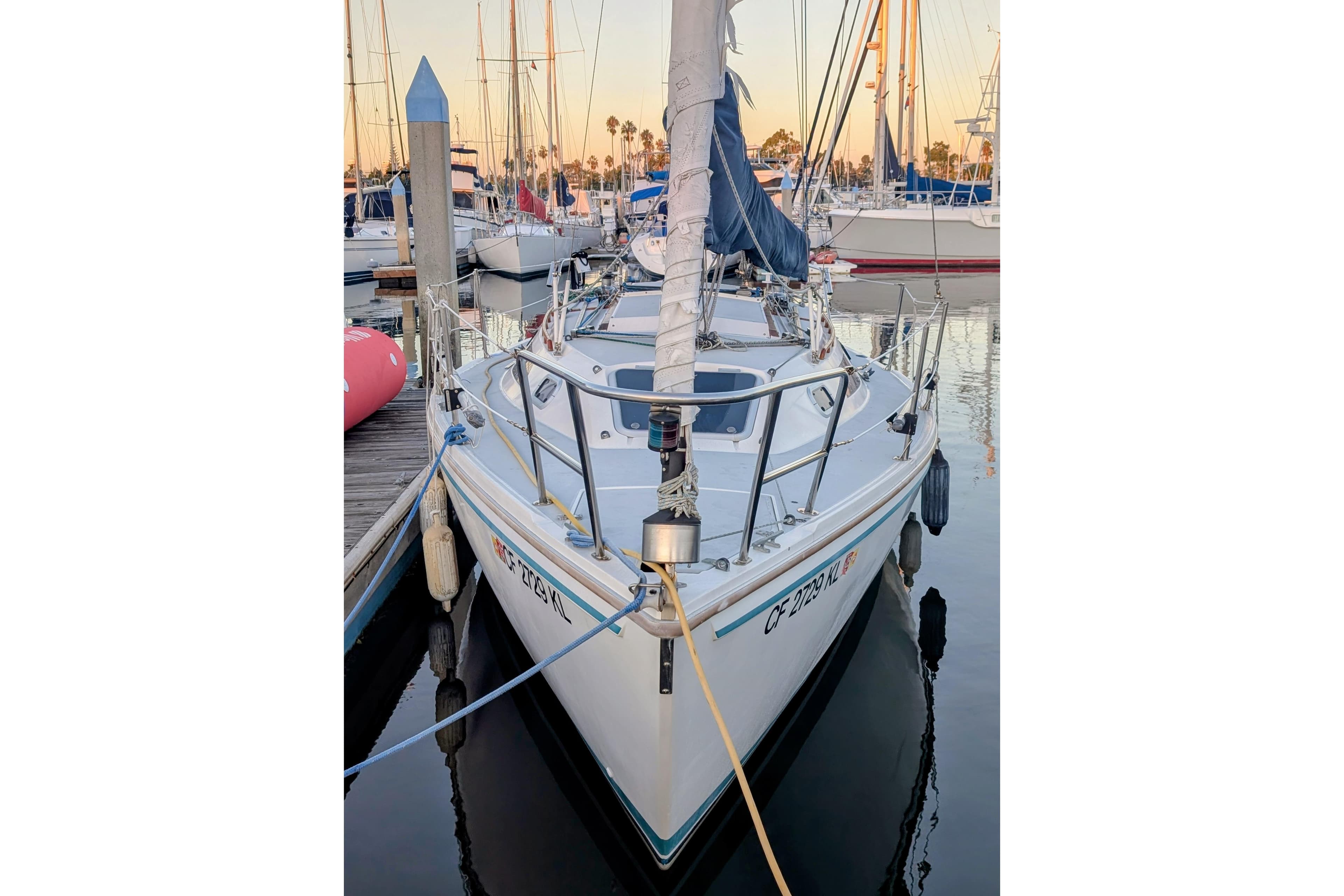 1990 Catalina Capri 26 sailboat docked at marina, front view.