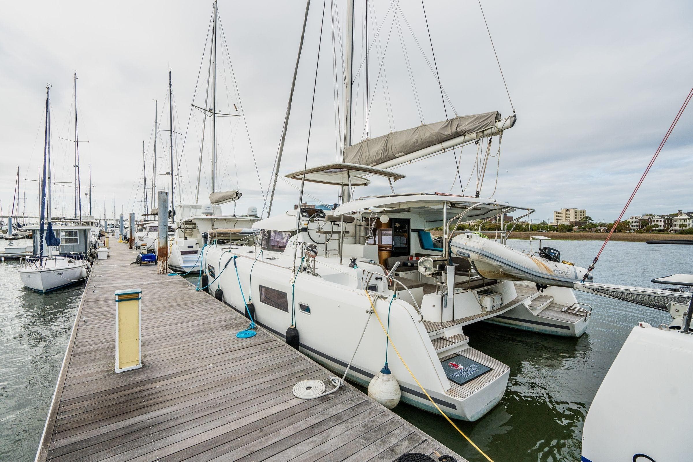 2017 Lagoon 42 catamaran docked at marina, surrounded by other sailboats.