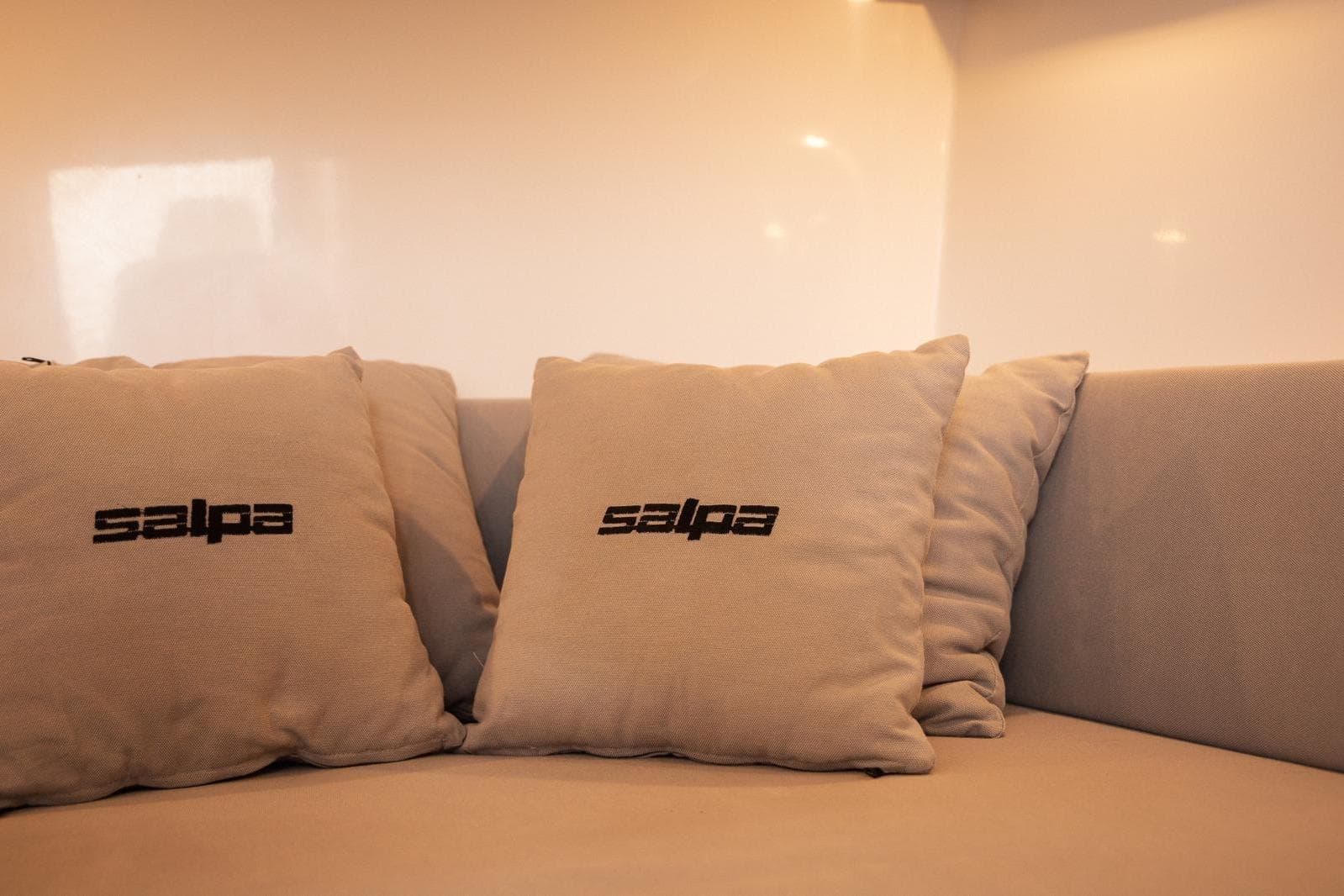Cushions with "Salpa" logo on a sofa, inside the 2025 Salpa SOLEIL 33 boat.