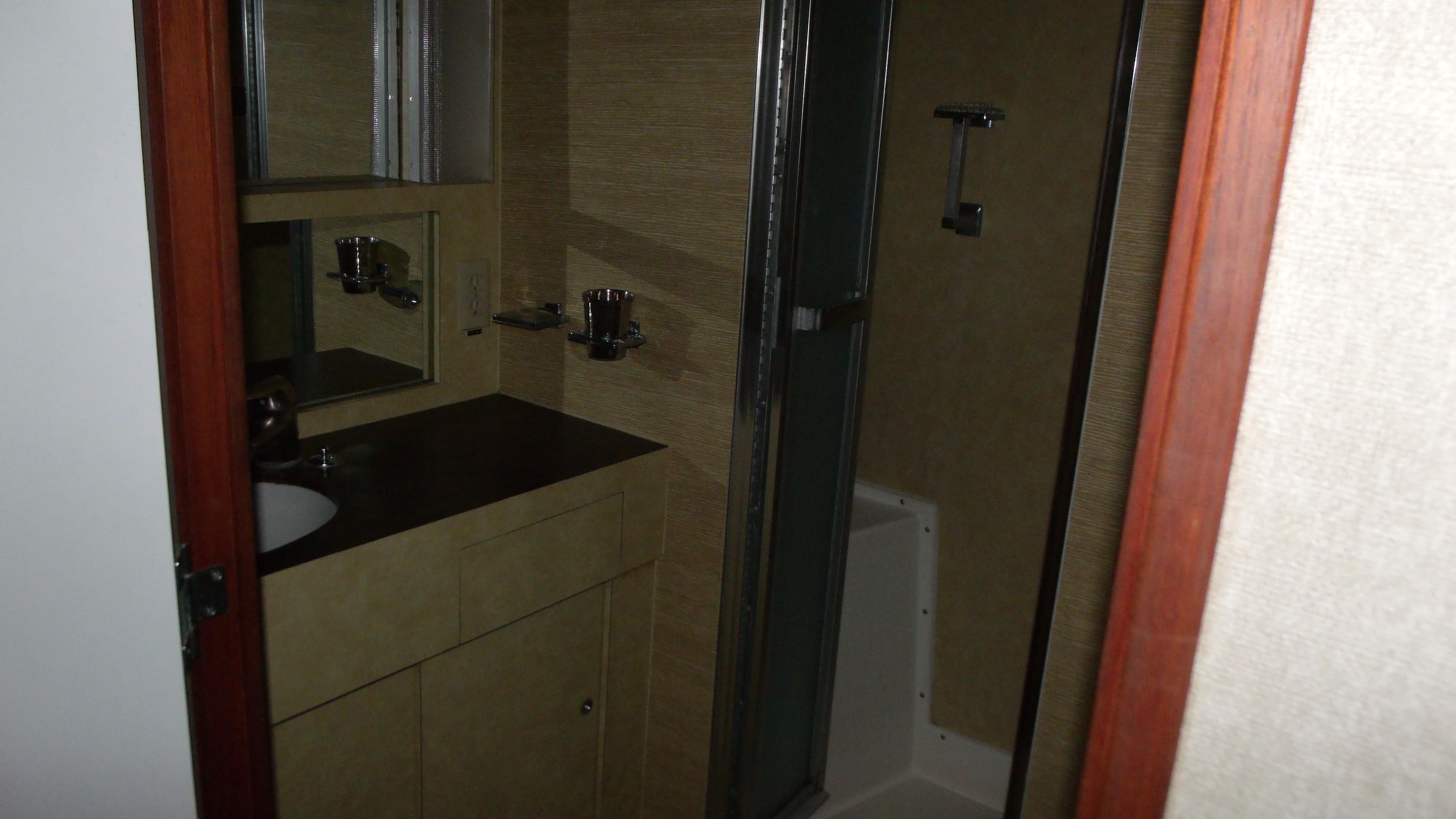 1978 Bertram 42 Convertible bathroom with sink, mirror, and shower.