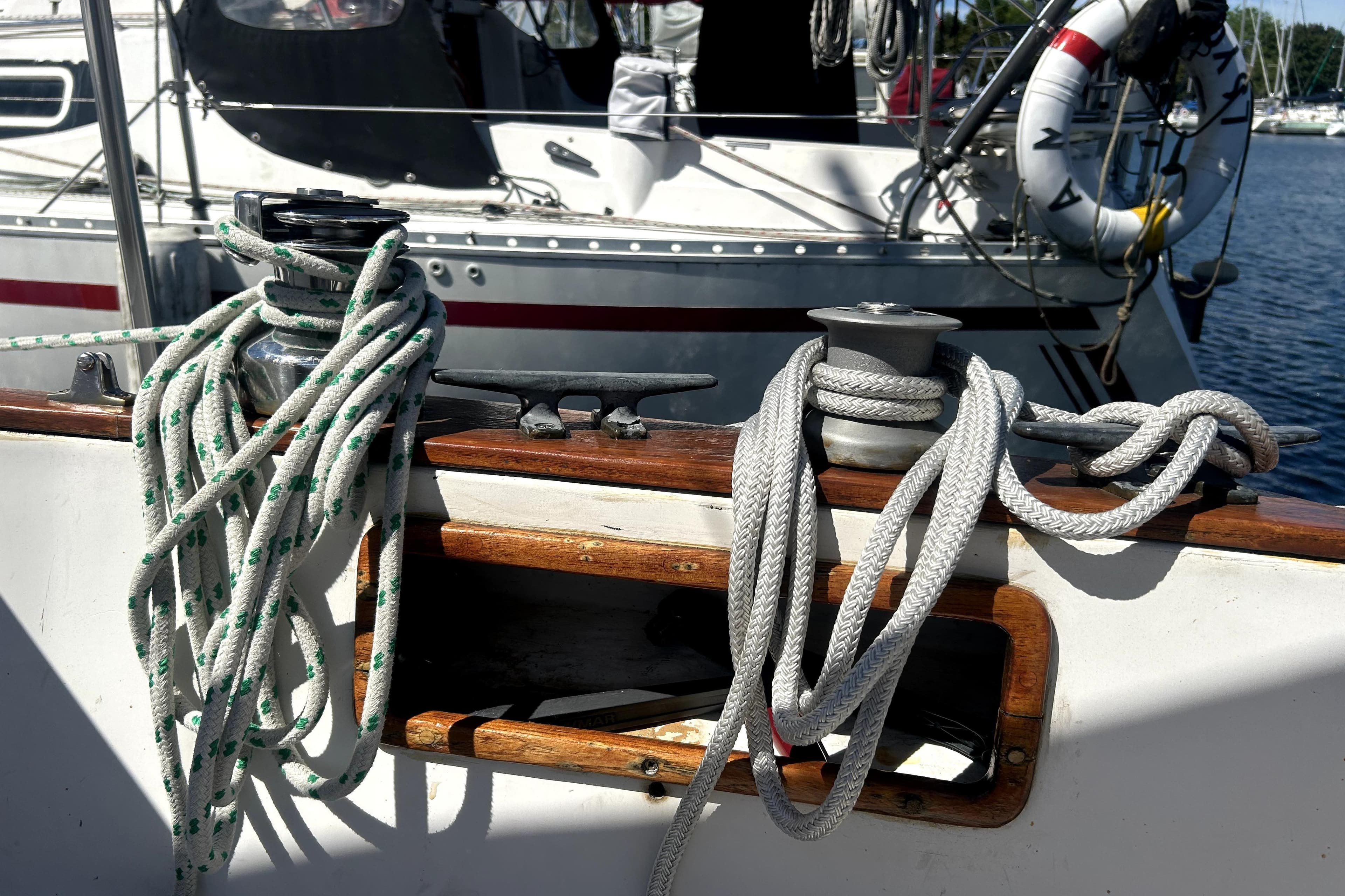 Ropes on a 1981 Bayfield 32 sailboat deck, with a winch and cleat in view.