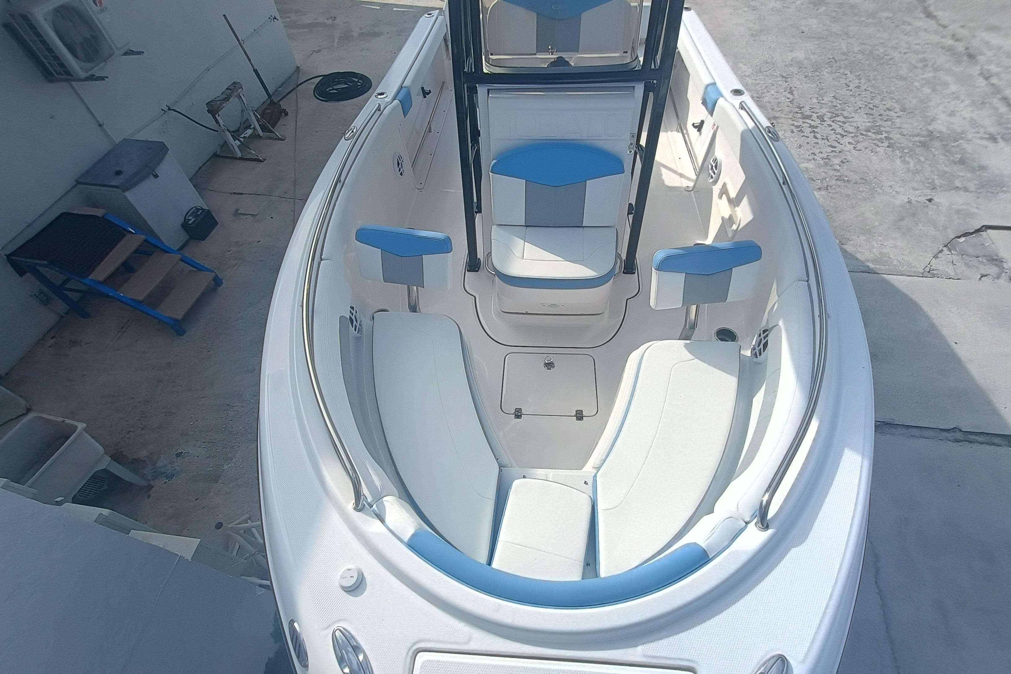 2026 Robalo R222 Explorer boat interior with white and blue seating, docked outdoors.