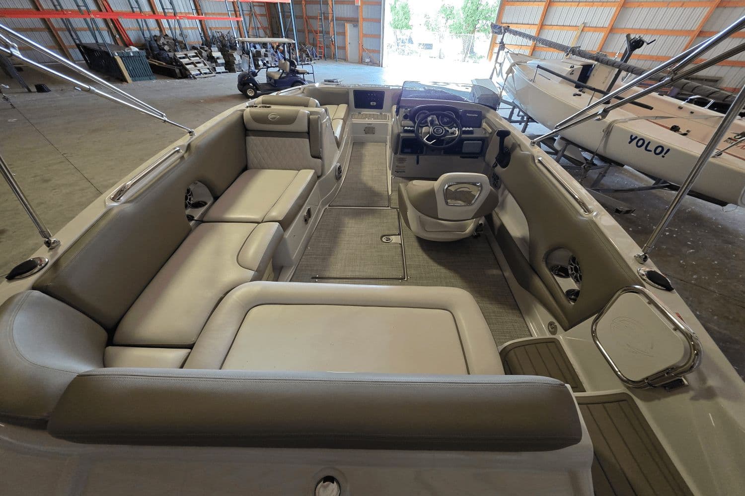 2021 Crownline E 205 XS boat interior with seating and steering wheel in a storage facility.