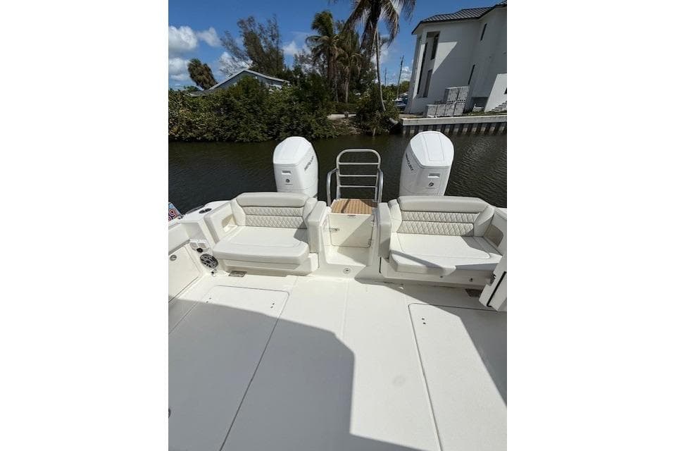 2026 World Cat 400 DC-X Island boat with dual engines and seating, docked by a canal.