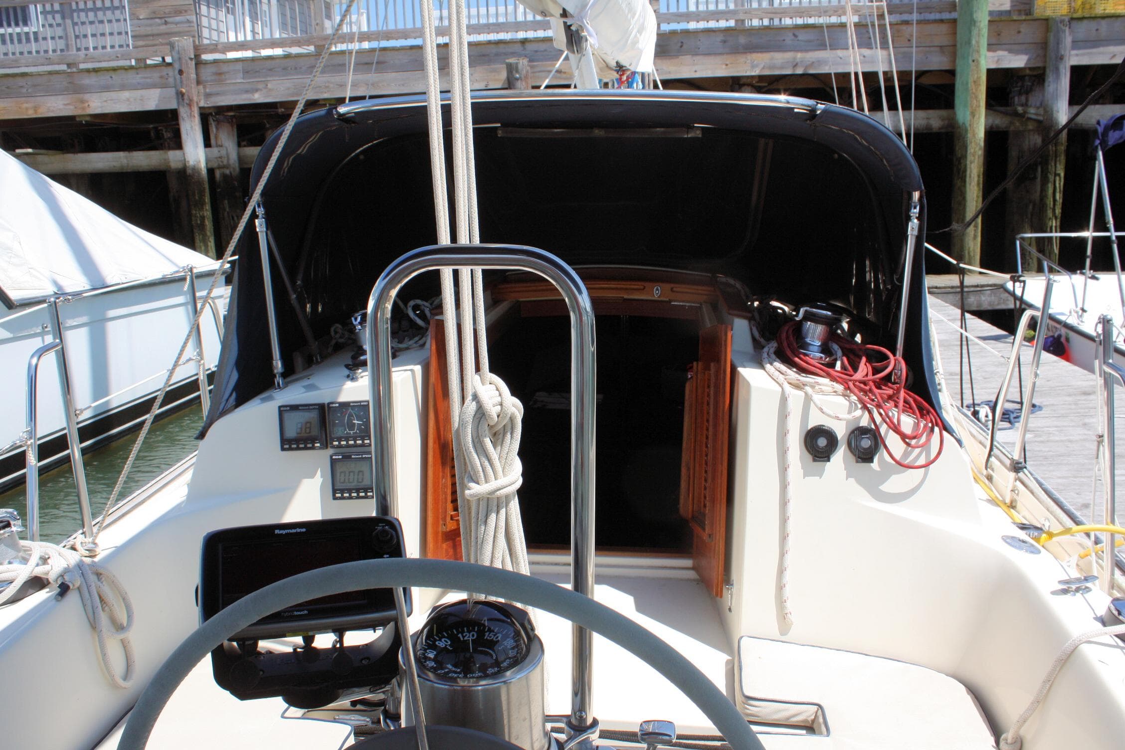 Cockpit of 2004 Pacific Seacraft 31 sailboat with navigation equipment and ropes.