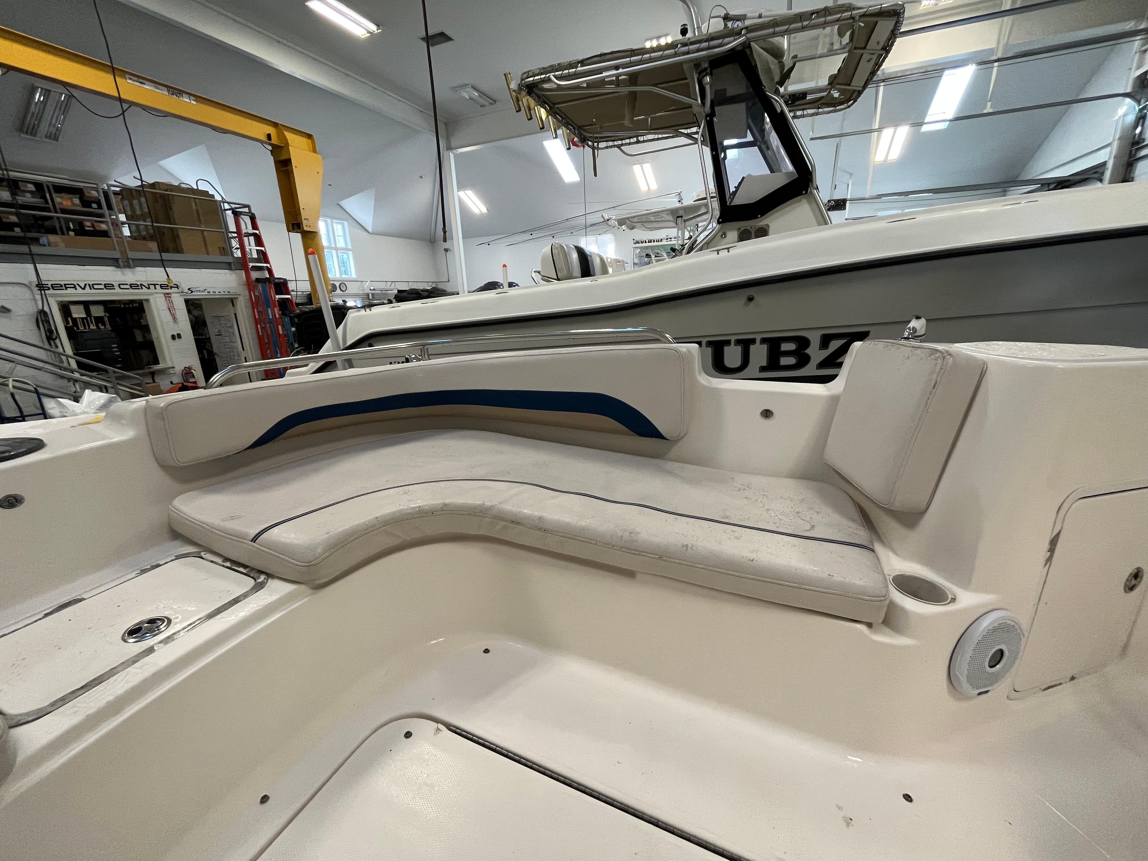 Interior of a 2005 Godfrey FD211 boat with cushioned seating in a garage.