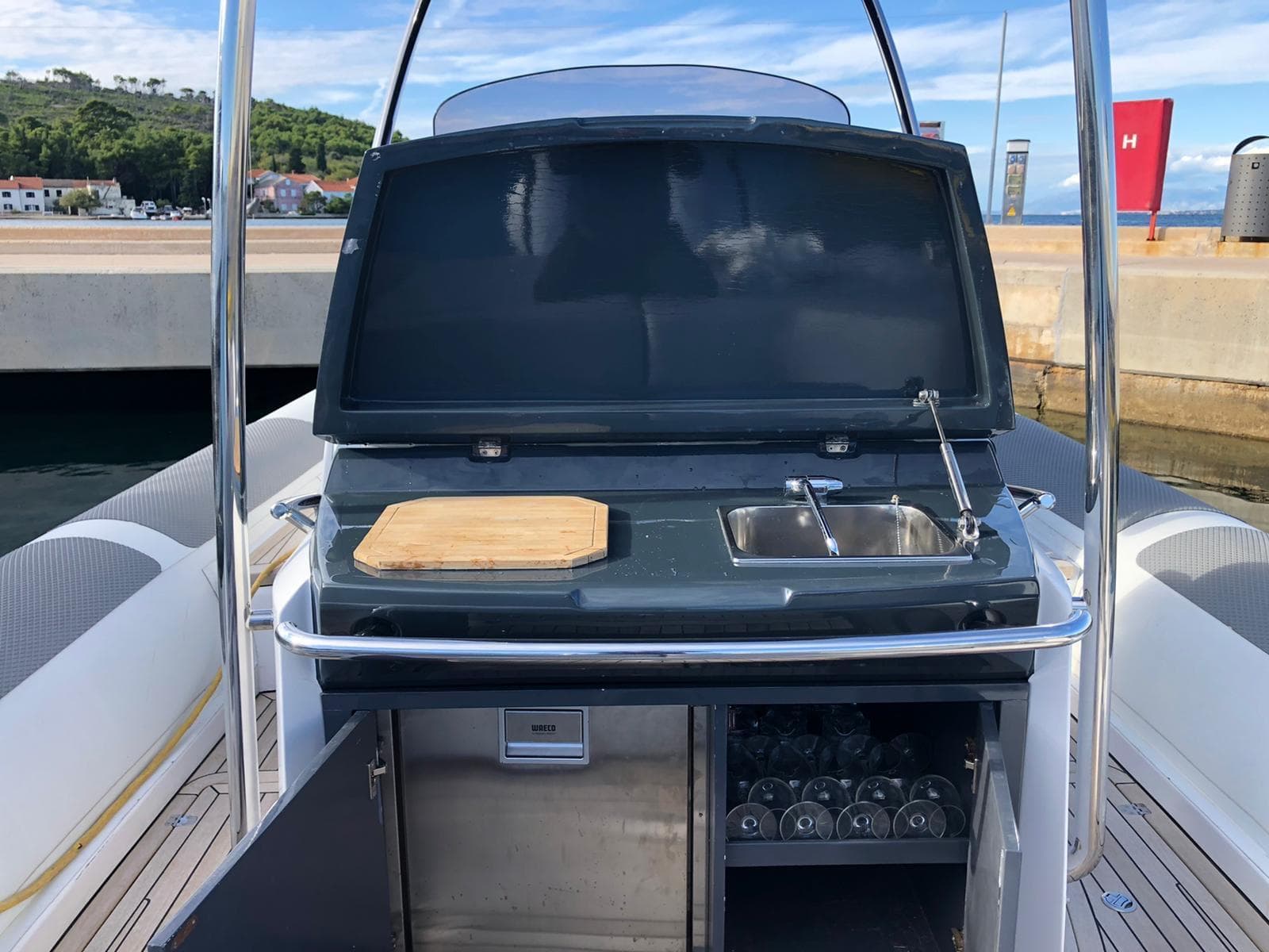 2009 SACS Strider 11 yacht with outdoor kitchenette, featuring sink and cutting board.