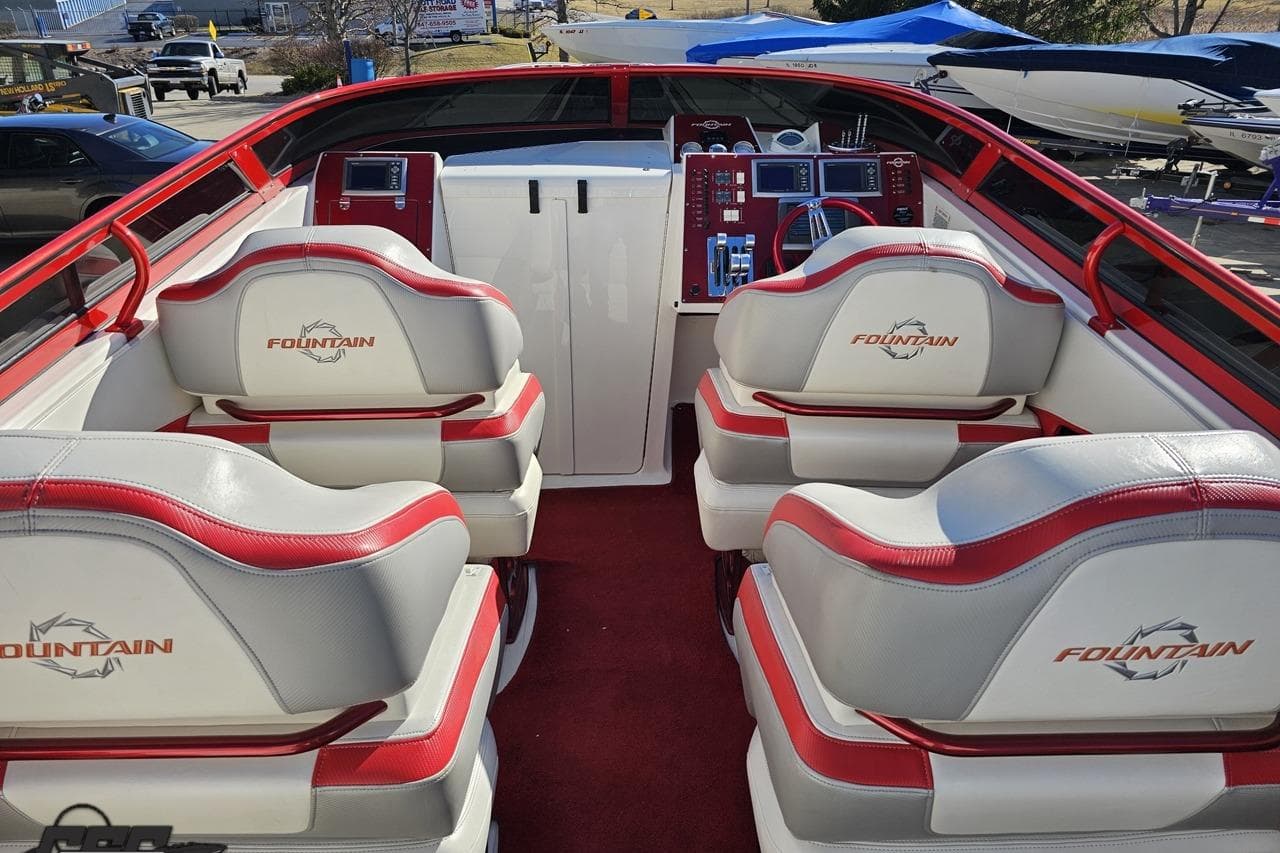 2009 Fountain 47 Lightning boat interior with red and white seating and control panel.