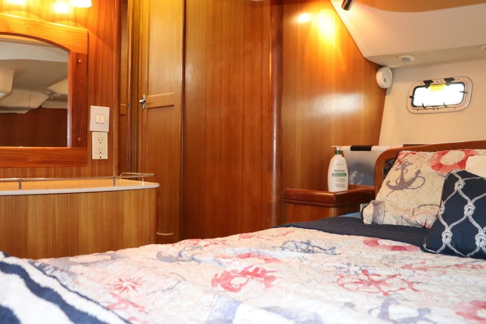 Cozy cabin interior of 2004 Hunter 41 AC sailboat with nautical-themed bedding.