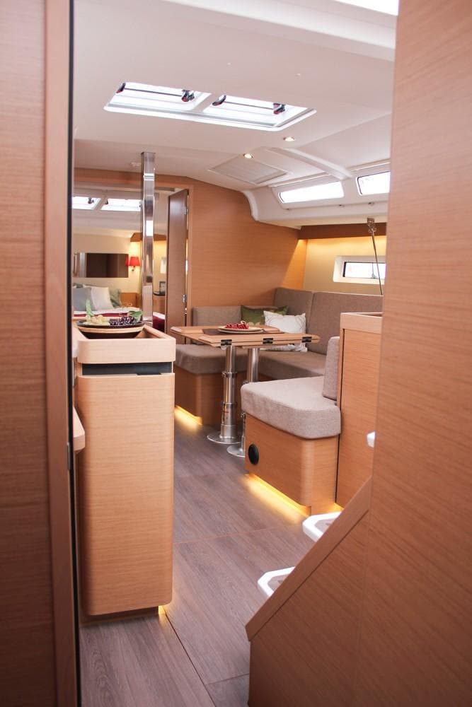 Interior of 2025 Jeanneau Sun Odyssey 440 yacht, featuring modern wood finishes and cozy seating.