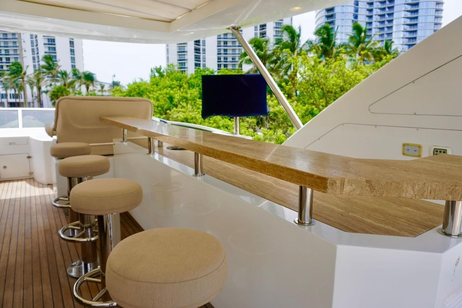 Luxurious 2015 Azimut 84 yacht deck with bar stools and scenic view.