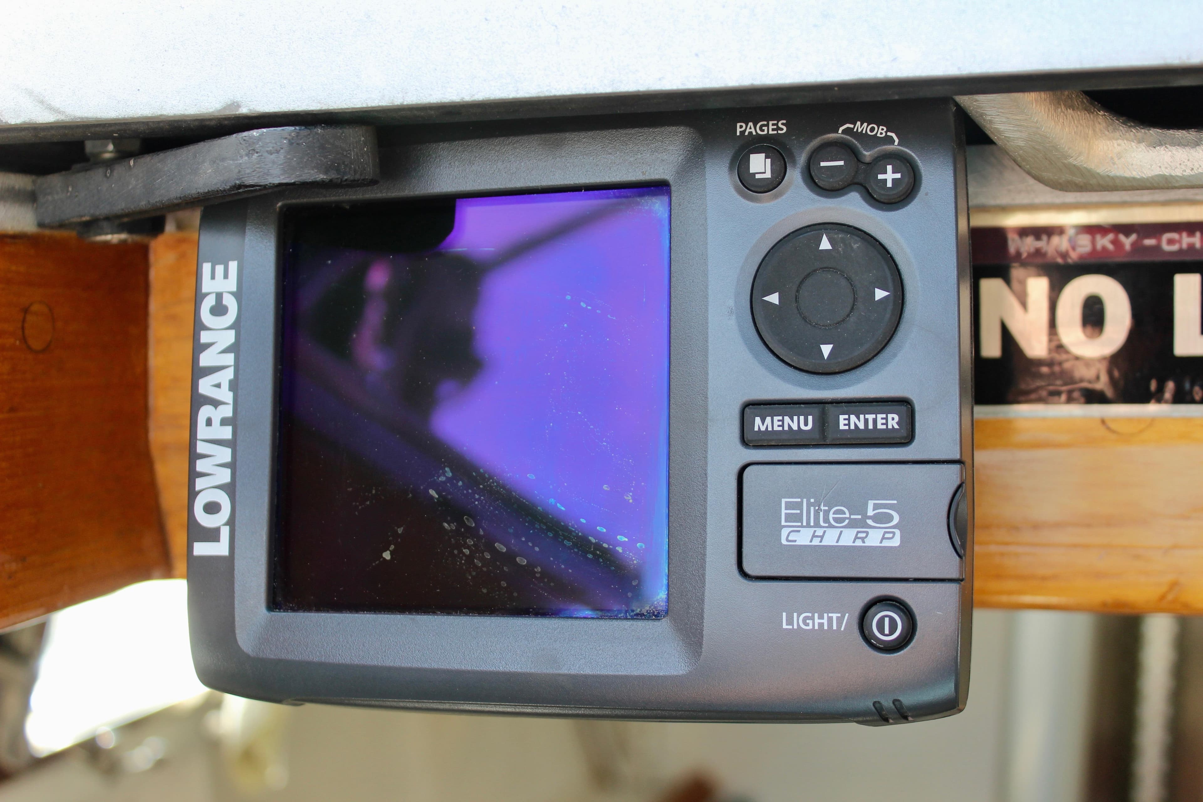 Lowrance Elite-5 CHIRP fishfinder on 1993 Freya 39 boat, mounted under a wooden panel.