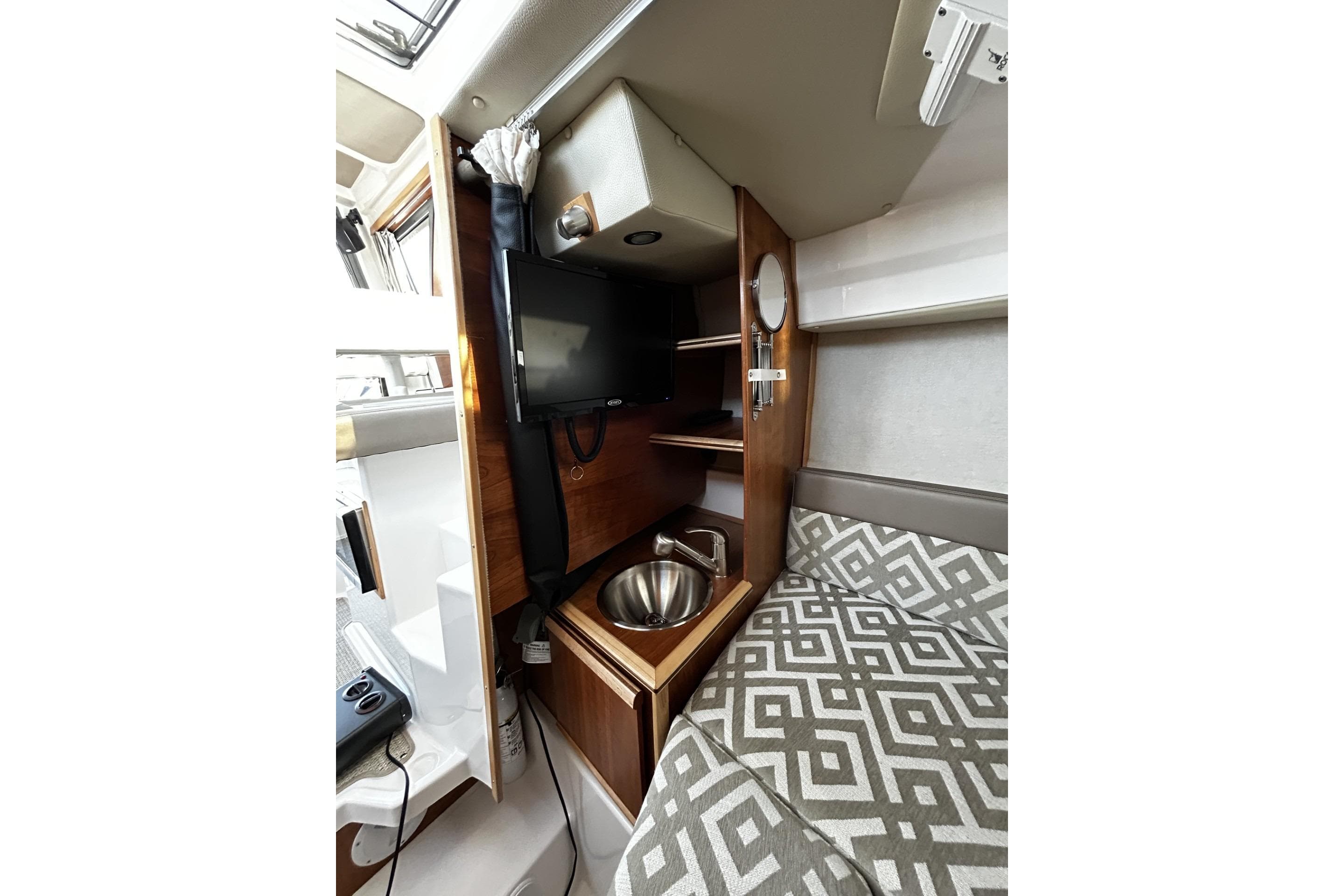 2024 Cutwater 248 interior with TV, sink, and patterned seating.
