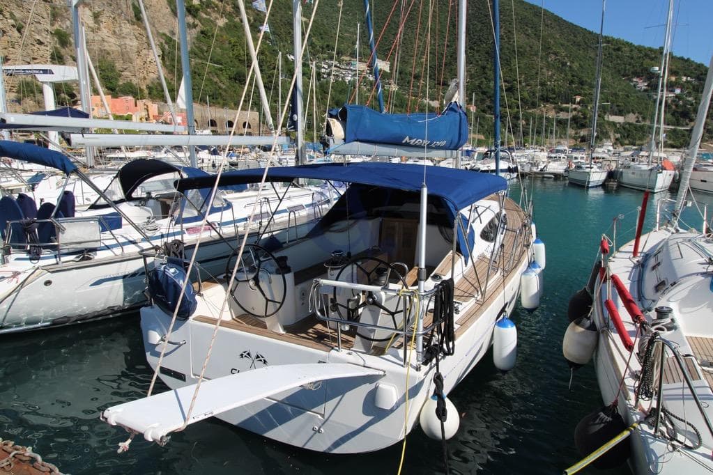 2016 Delphia Maxi 1200 sailboat docked in a marina, surrounded by other boats.