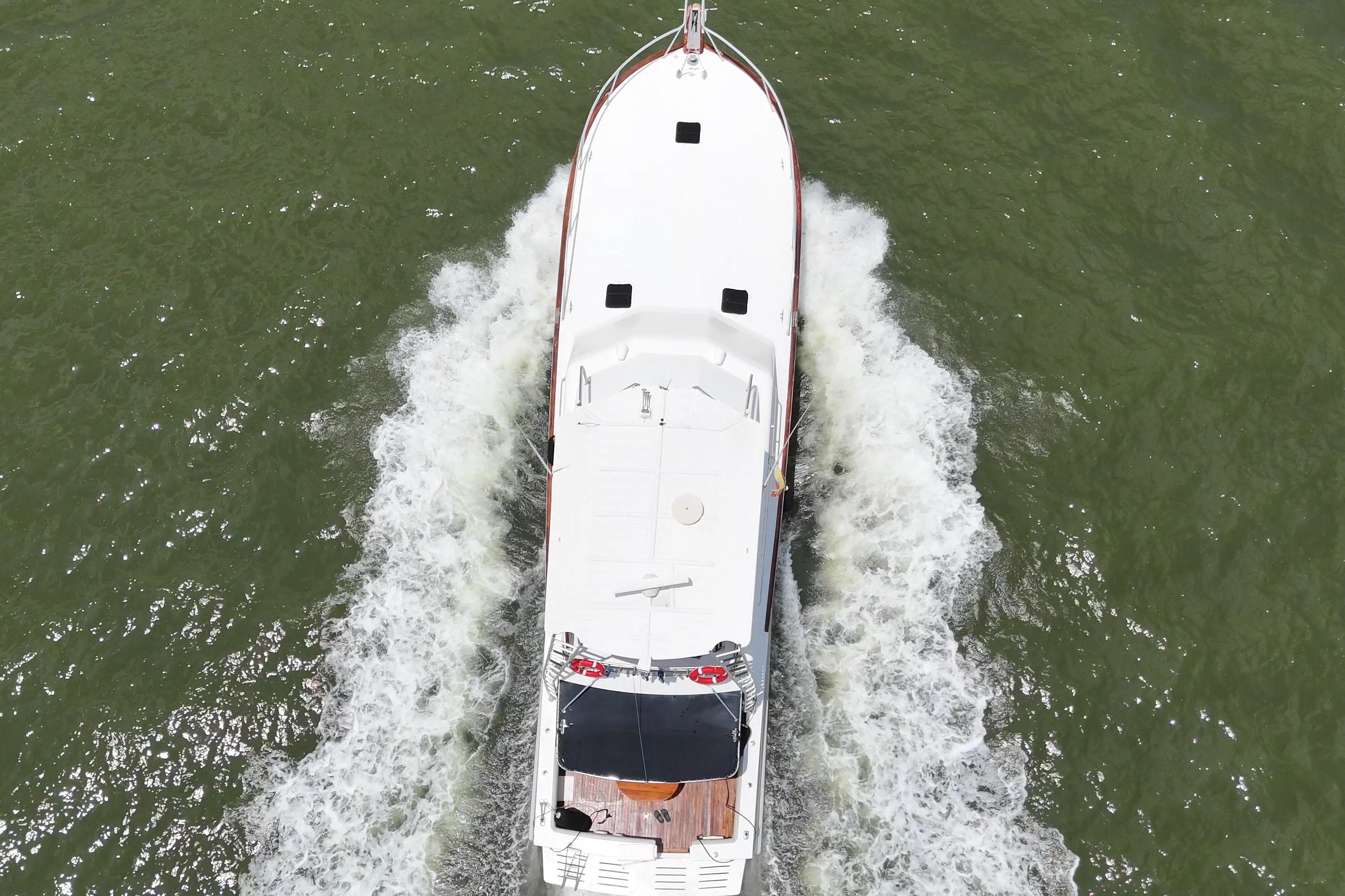 Aerial view of 1989 Buddy Davis 61 yacht cruising on green water.