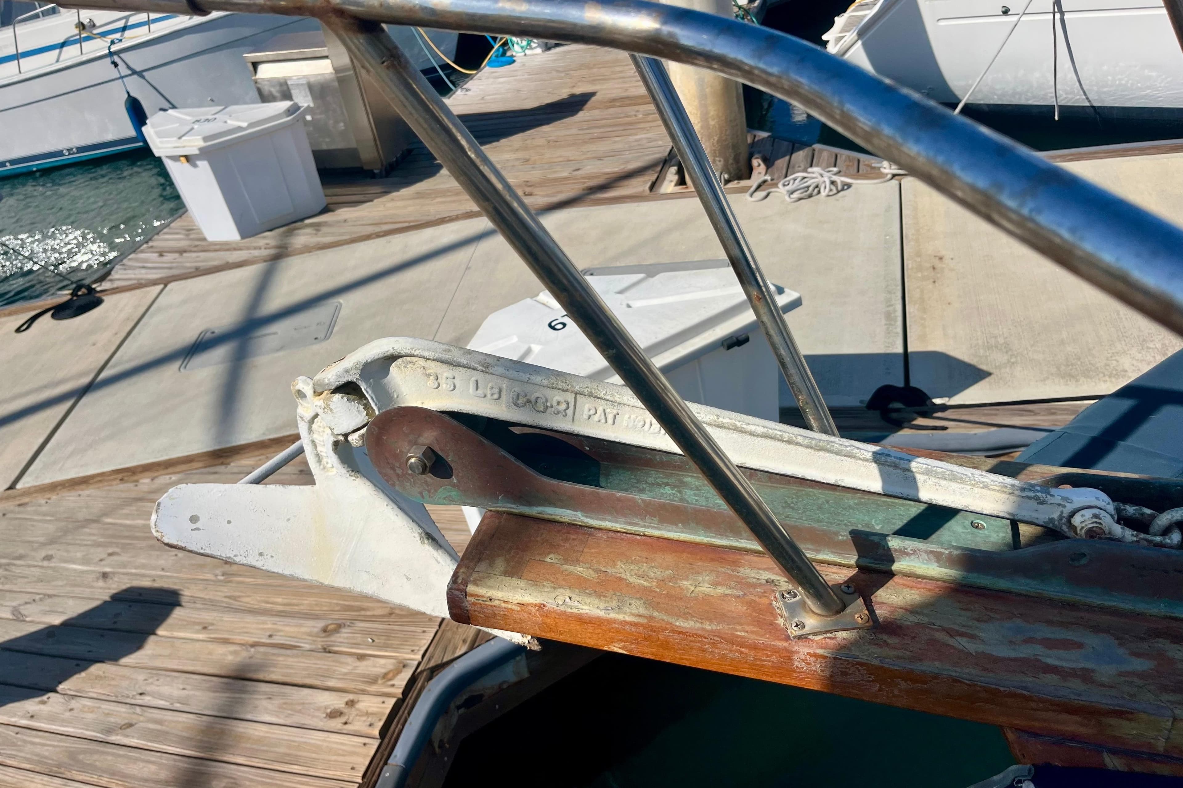 Bow of a 1978 C&L 37 sailboat with anchor roller at marina.