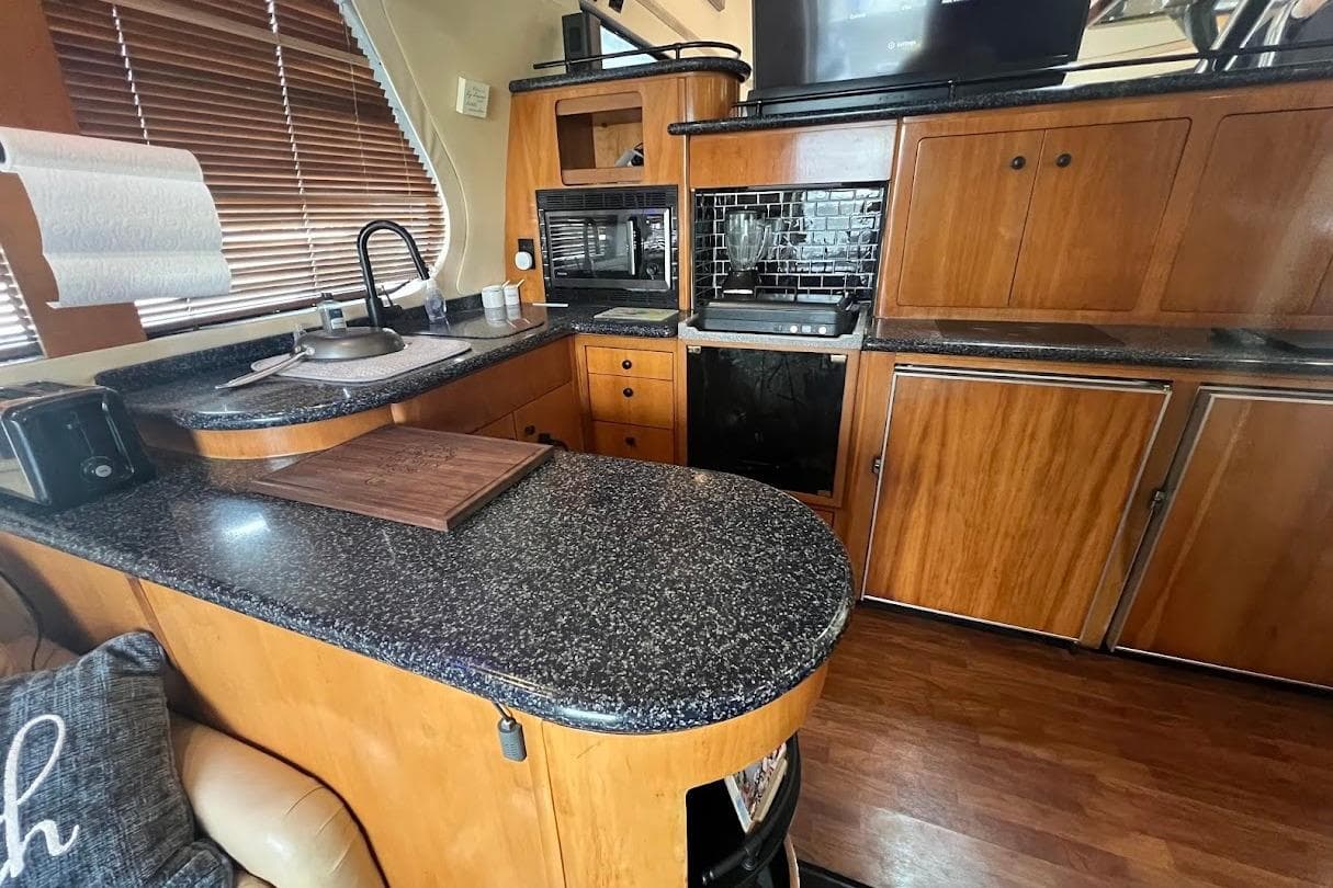 Luxurious kitchen interior of 2000 Carver 530 Voyager Pilothouse yacht with wood cabinetry.