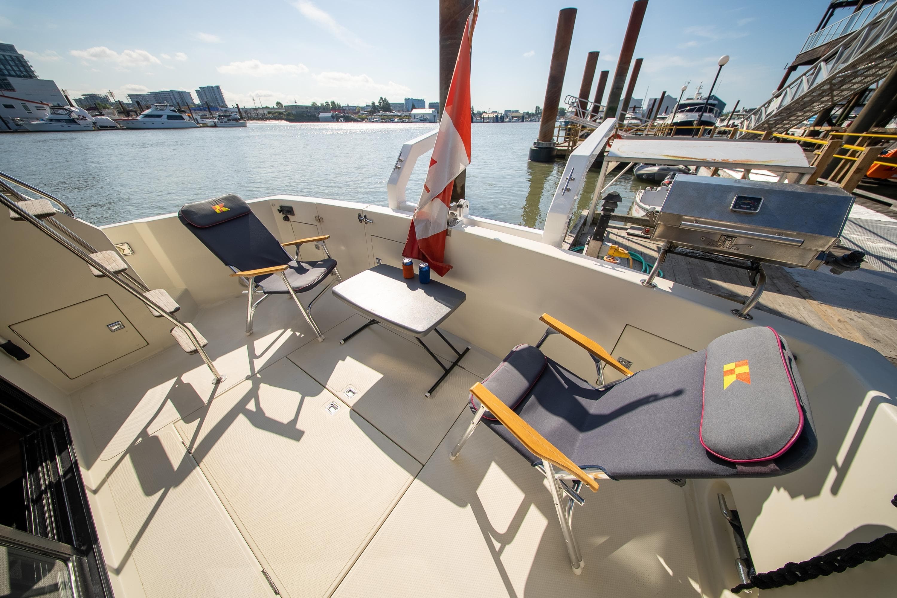 1990 Tollycraft 44 Sedan yacht deck with chairs, table, and marina view.