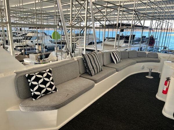 2005 Sumerset 90x18 houseboat with spacious seating and decorative cushions in a marina.