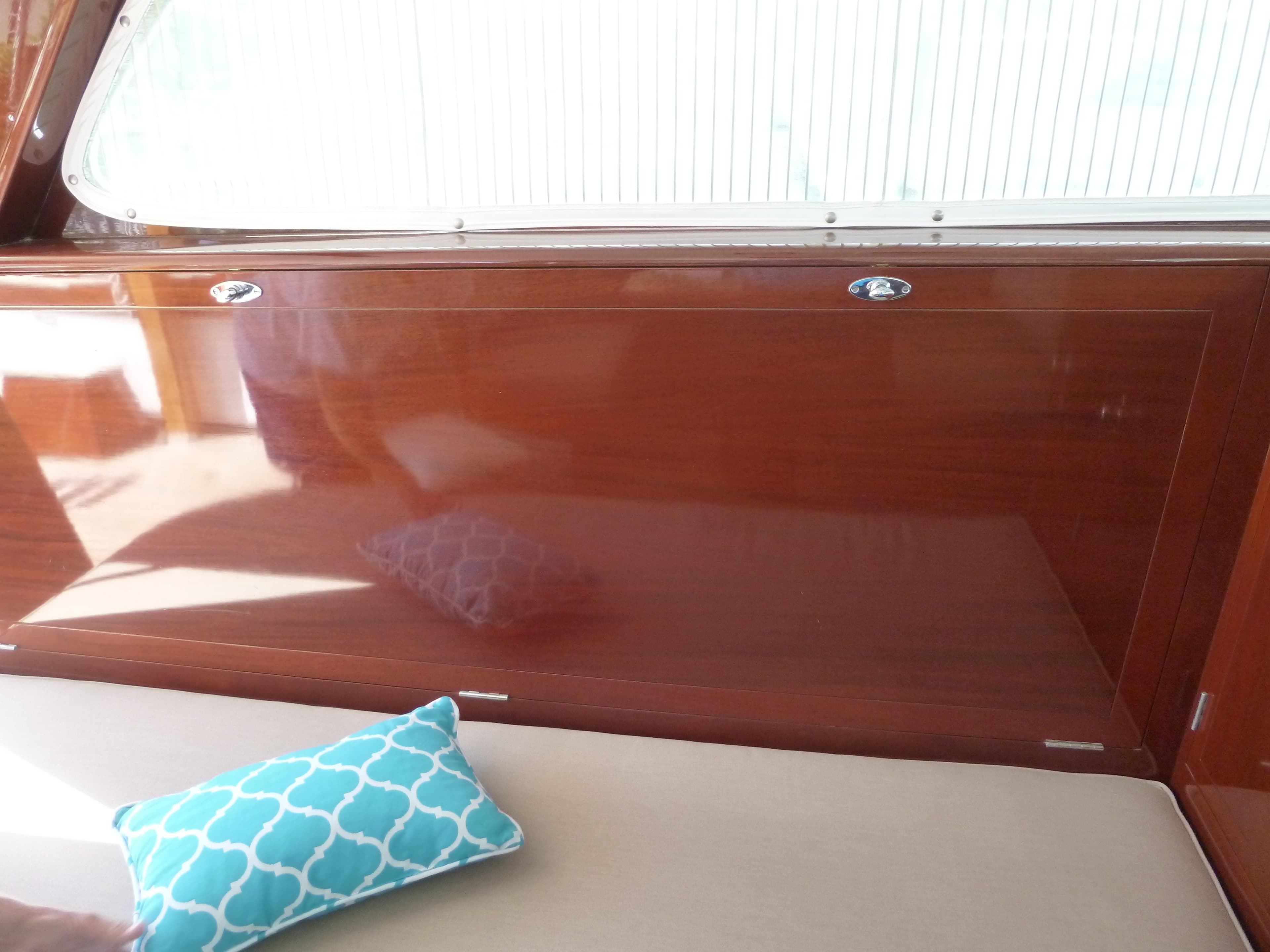 1949 Rybovich Sport Fish interior with polished wood and decorative cushion.