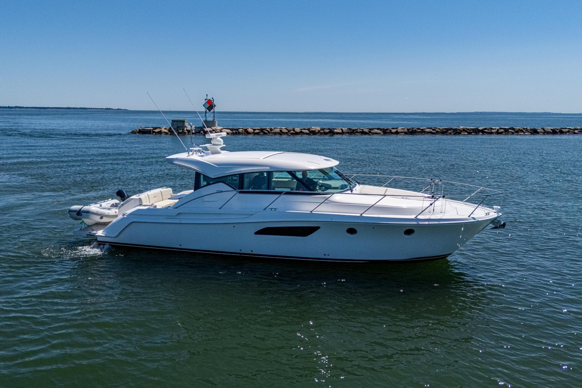 2020 Tiara Yachts C44 Coupe cruising on open water under clear blue skies.