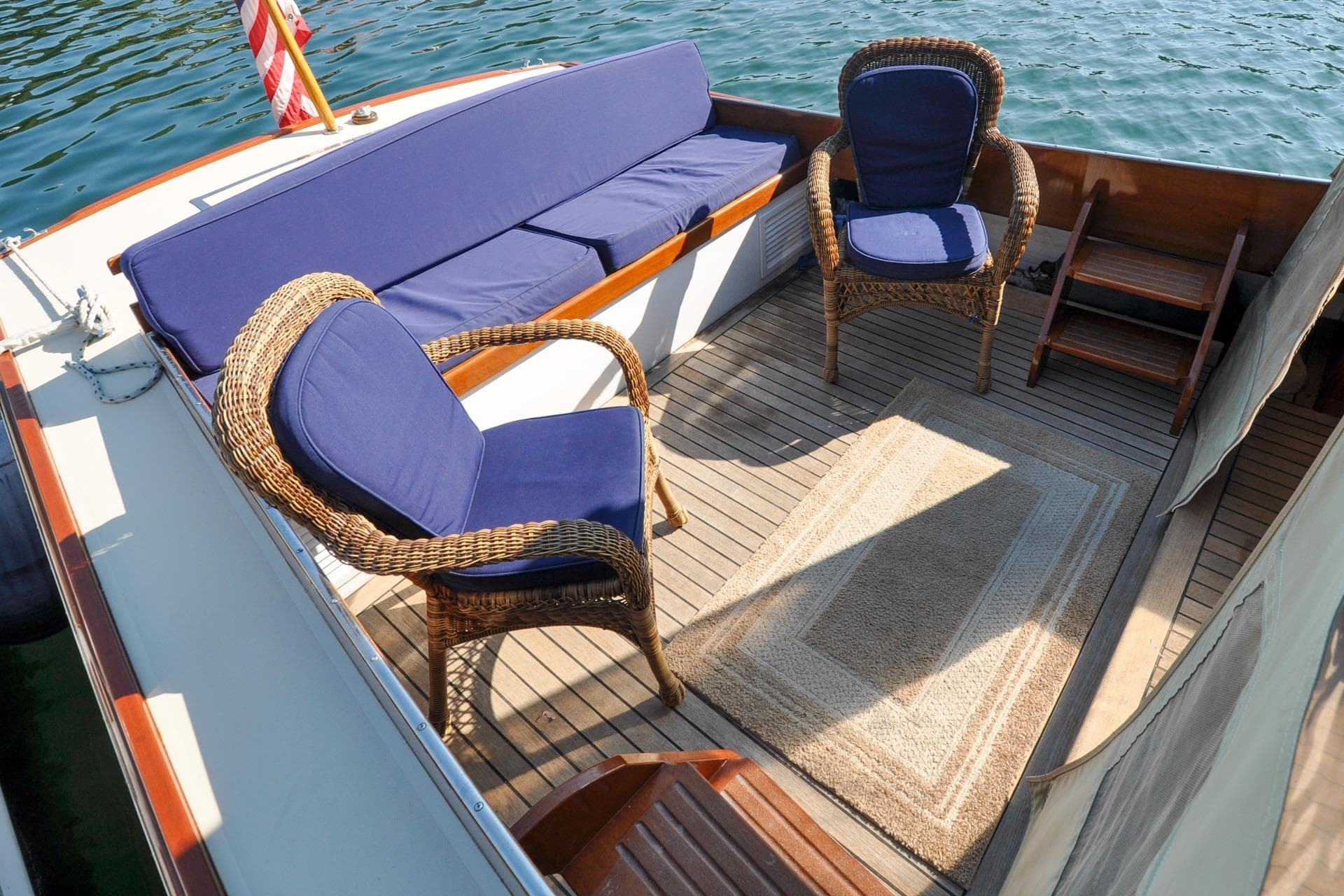1958 Bunker and Ellis 42 boat deck with wicker chairs and blue cushions.