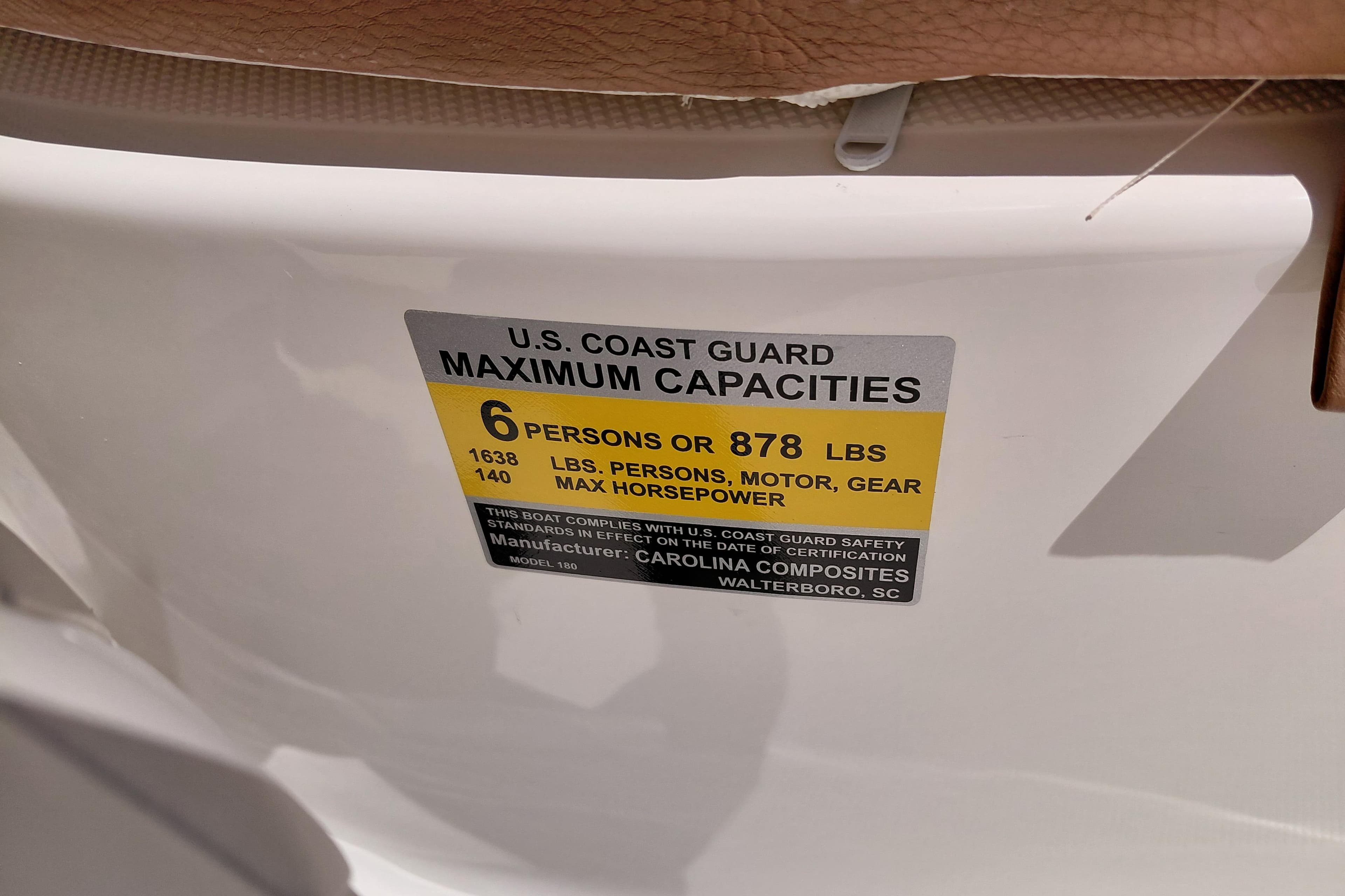 U.S. Coast Guard capacity label on 2026 Pioneer 180 Islander boat, 6 persons or 878 lbs.