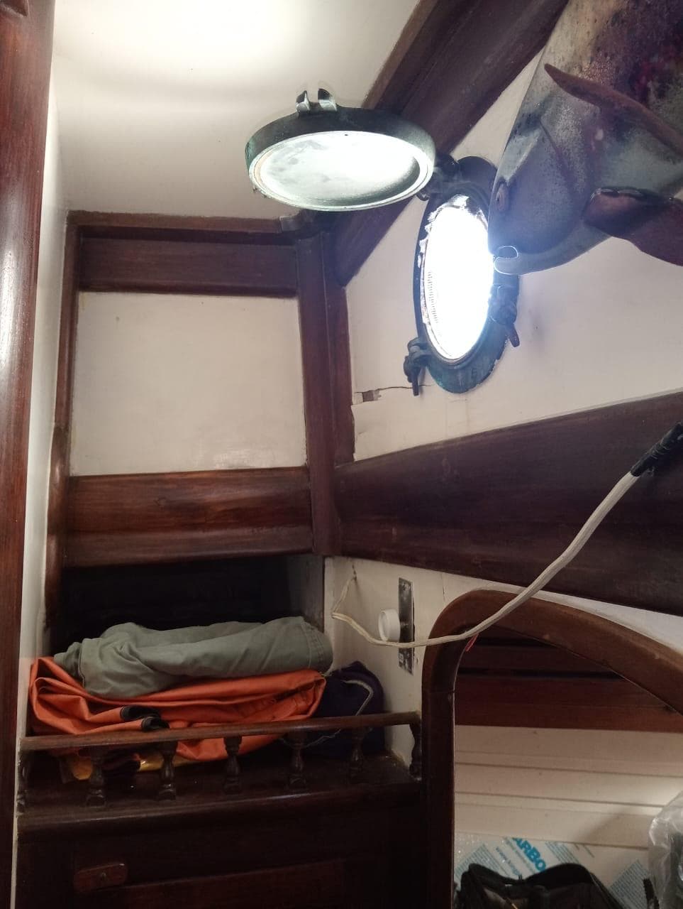 Interior of a 1973 Formosa 41 sailboat with wooden accents and porthole.