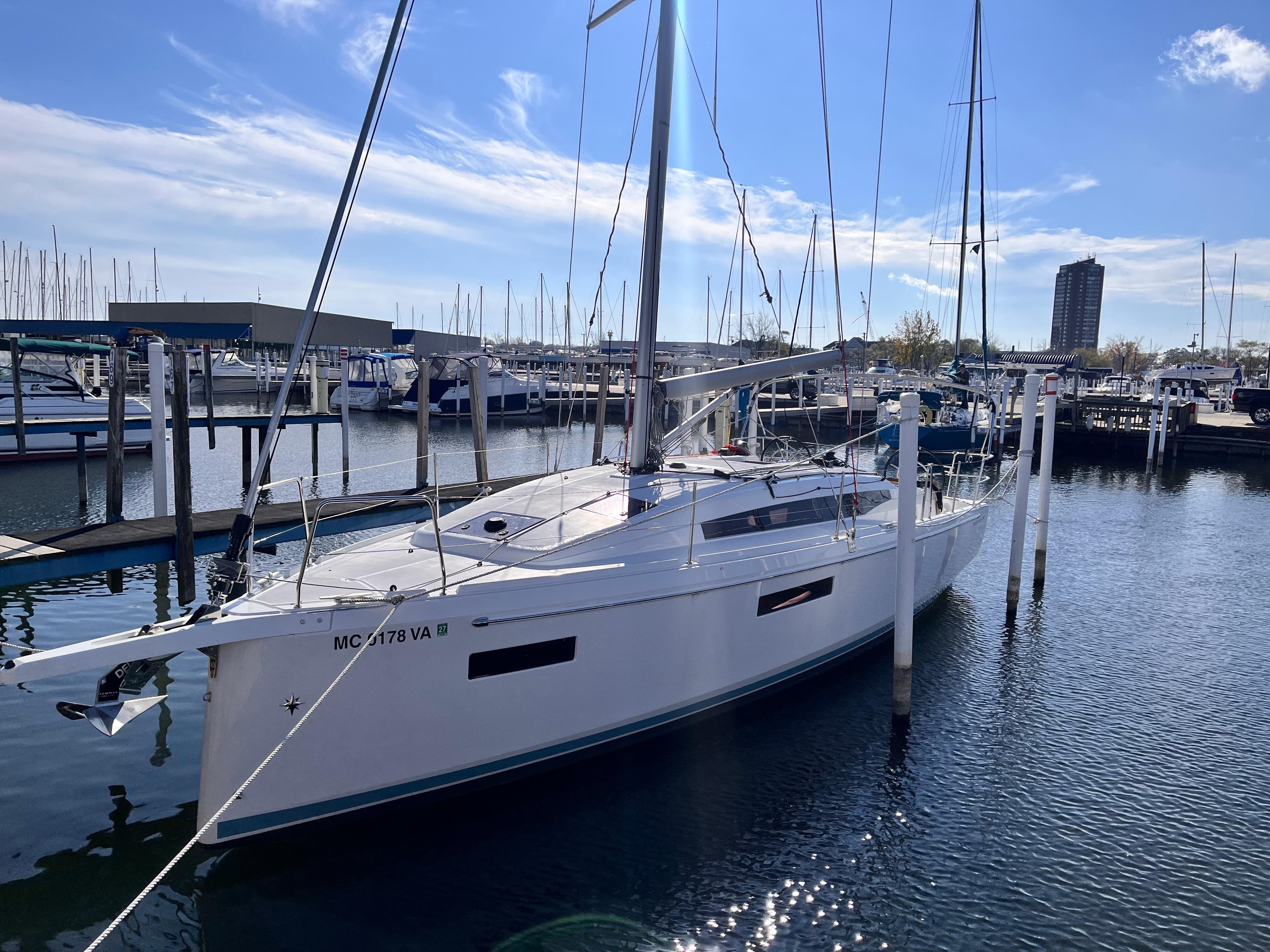 2024 Jeanneau 380 sailboat docked in a marina under a clear blue sky.