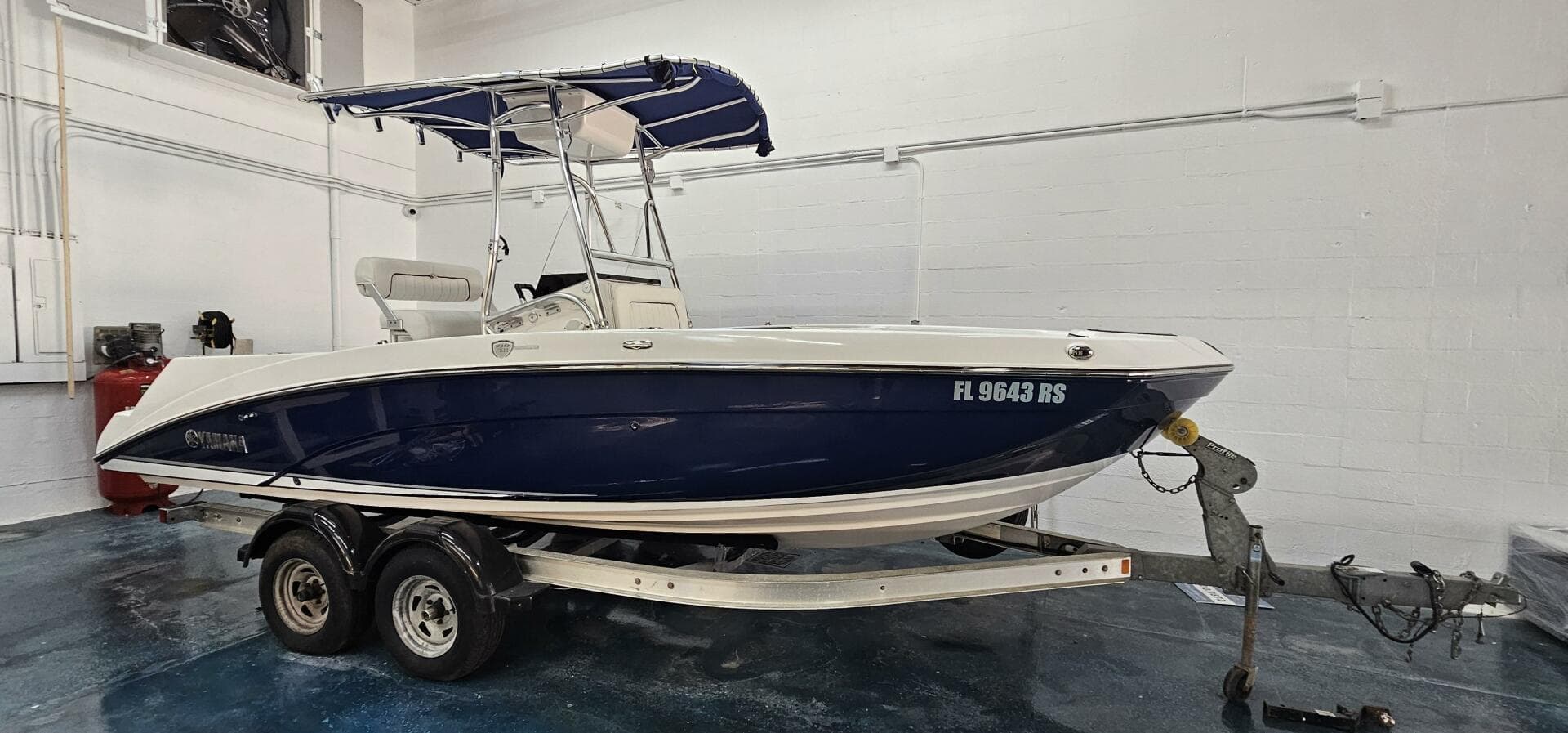 2018 Yamaha Boats 210 FSH Deluxe on trailer in indoor storage.