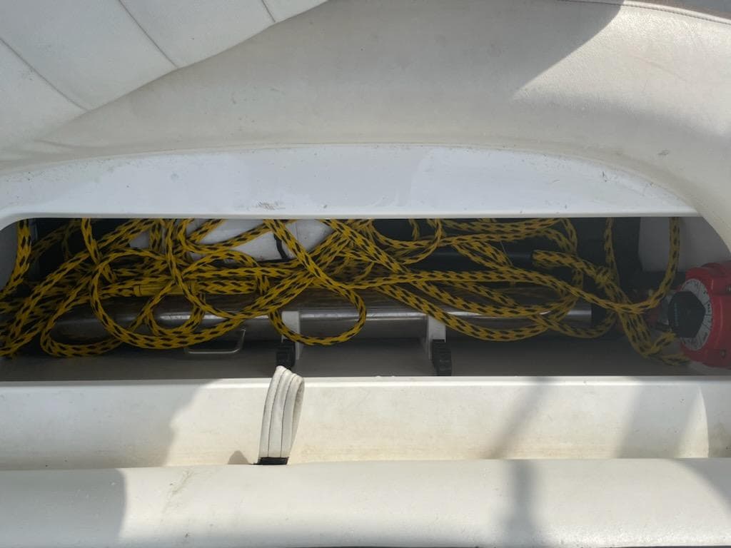 Storage compartment with yellow rope in a 2005 Cobalt 246 boat.