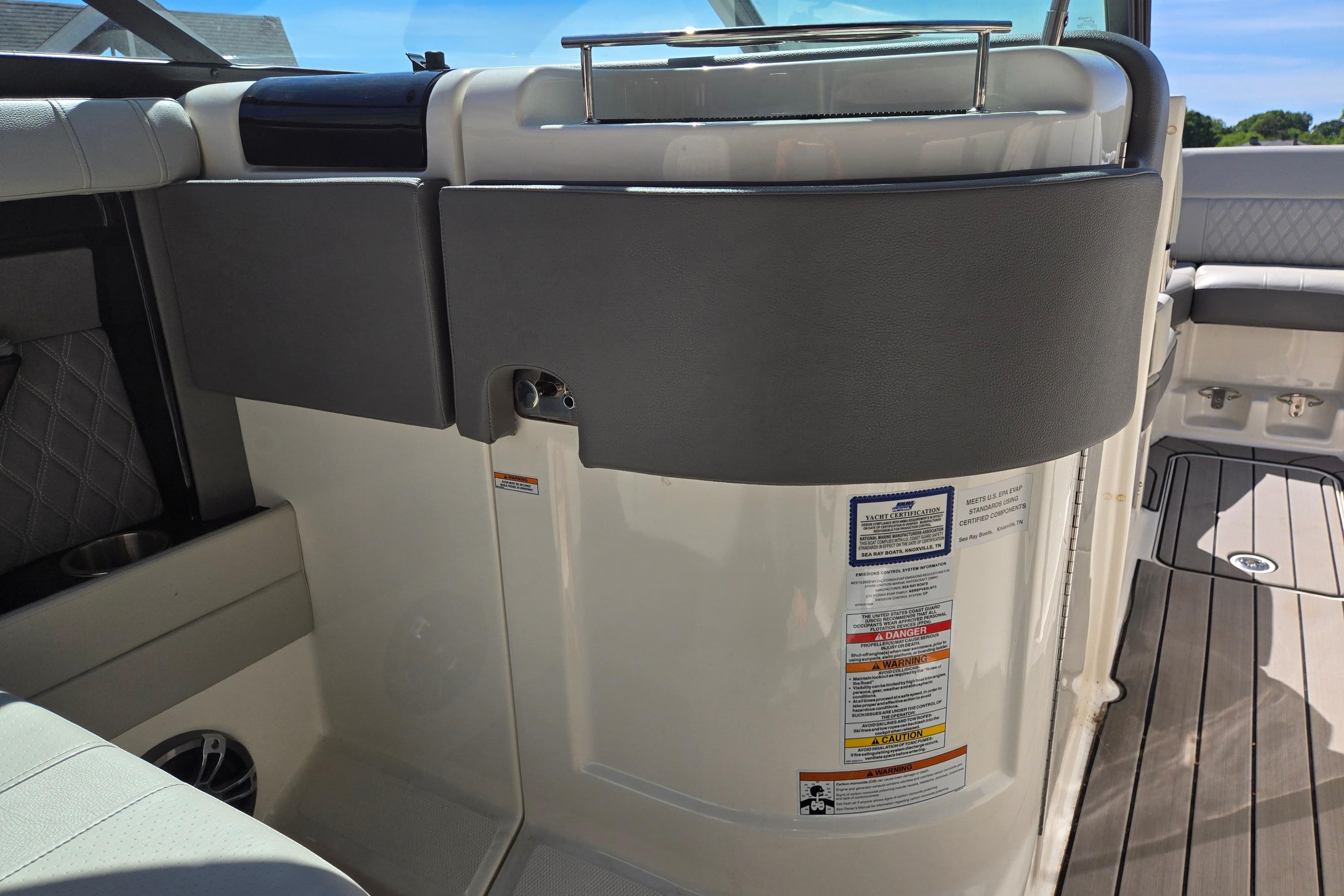 Interior view of a 2022 Sea Ray SLX 280 boat, featuring seating and safety labels.