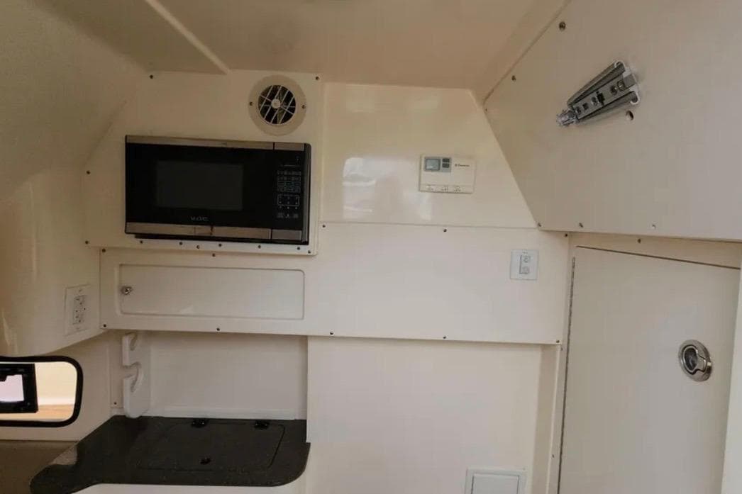 Interior of 2017 Scout 350 LXF boat with microwave and storage compartments.